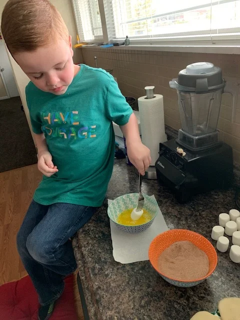 The fun part. You can totally use your hands but my son likes to use a fork. In with the butter, and then the cinnamon sugar mix.