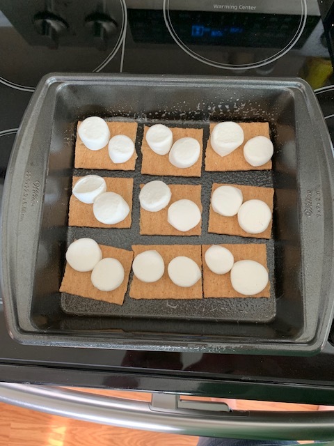 2. Grab your marshmallows and layer them on top of your graham crackers. I cut my marshmallows in half, they seem to stay put better and melt better. If you like gooey, add more marshmallows than I did in my picture.