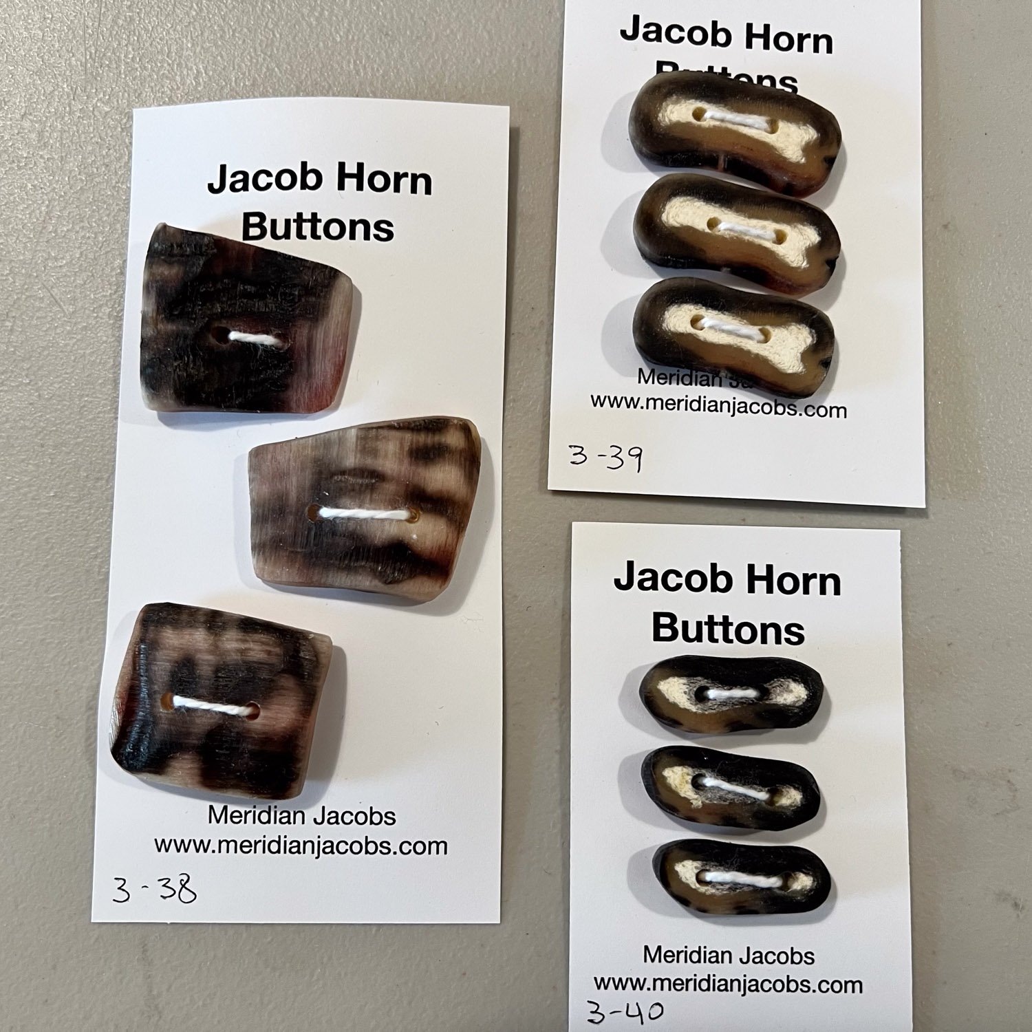 Three cards of three Jacob horn buttons.
