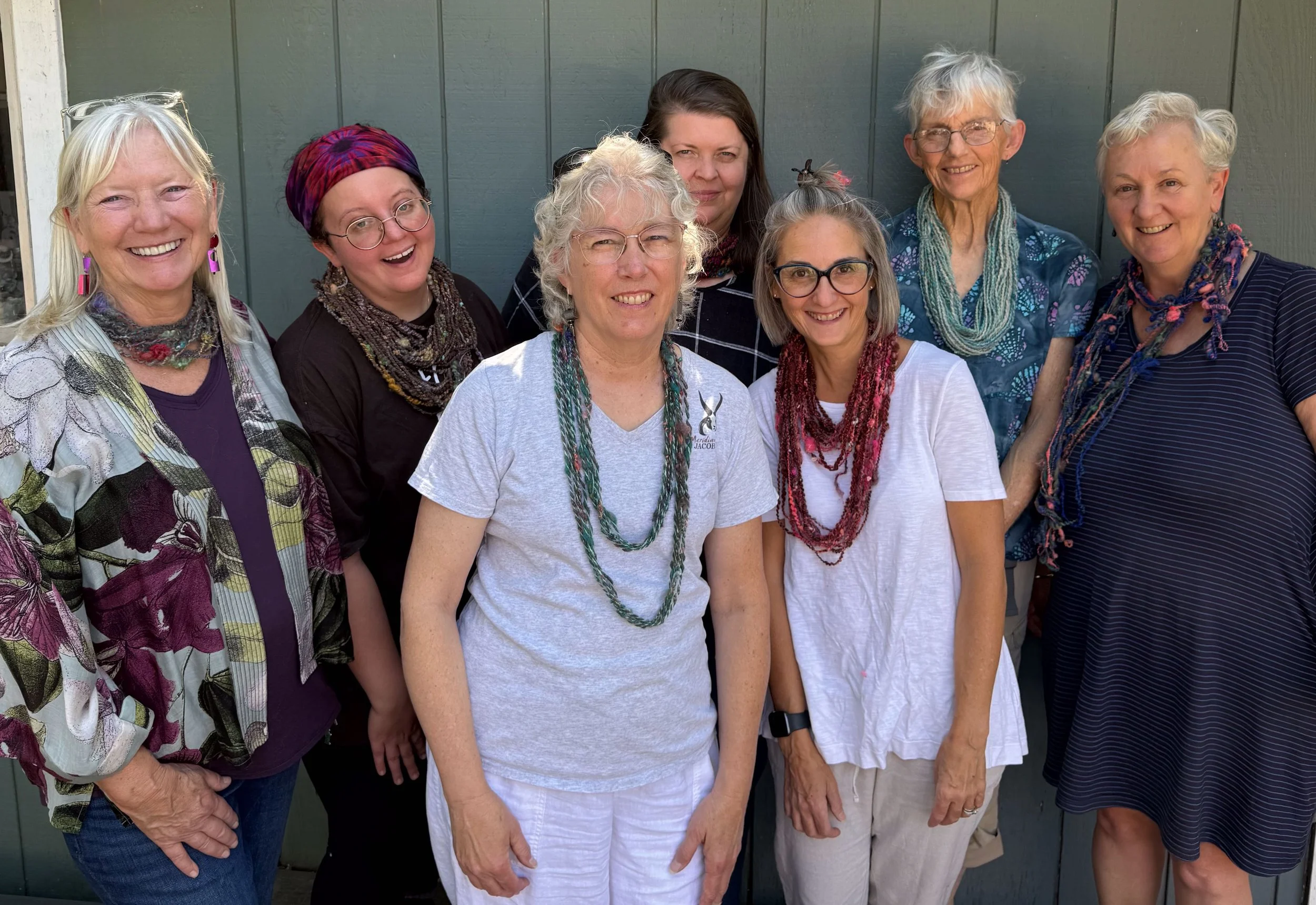 Group of women wearing their art yarn skeins as necklaces.