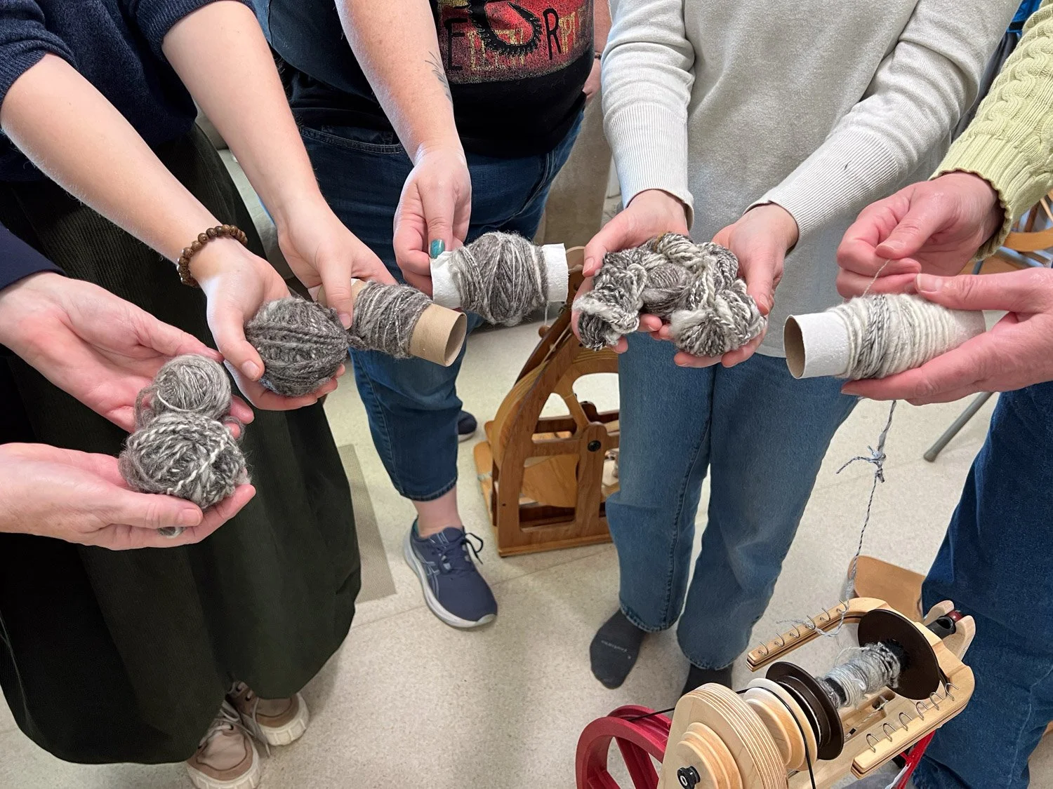 Hands showing first yarn spun in a class.