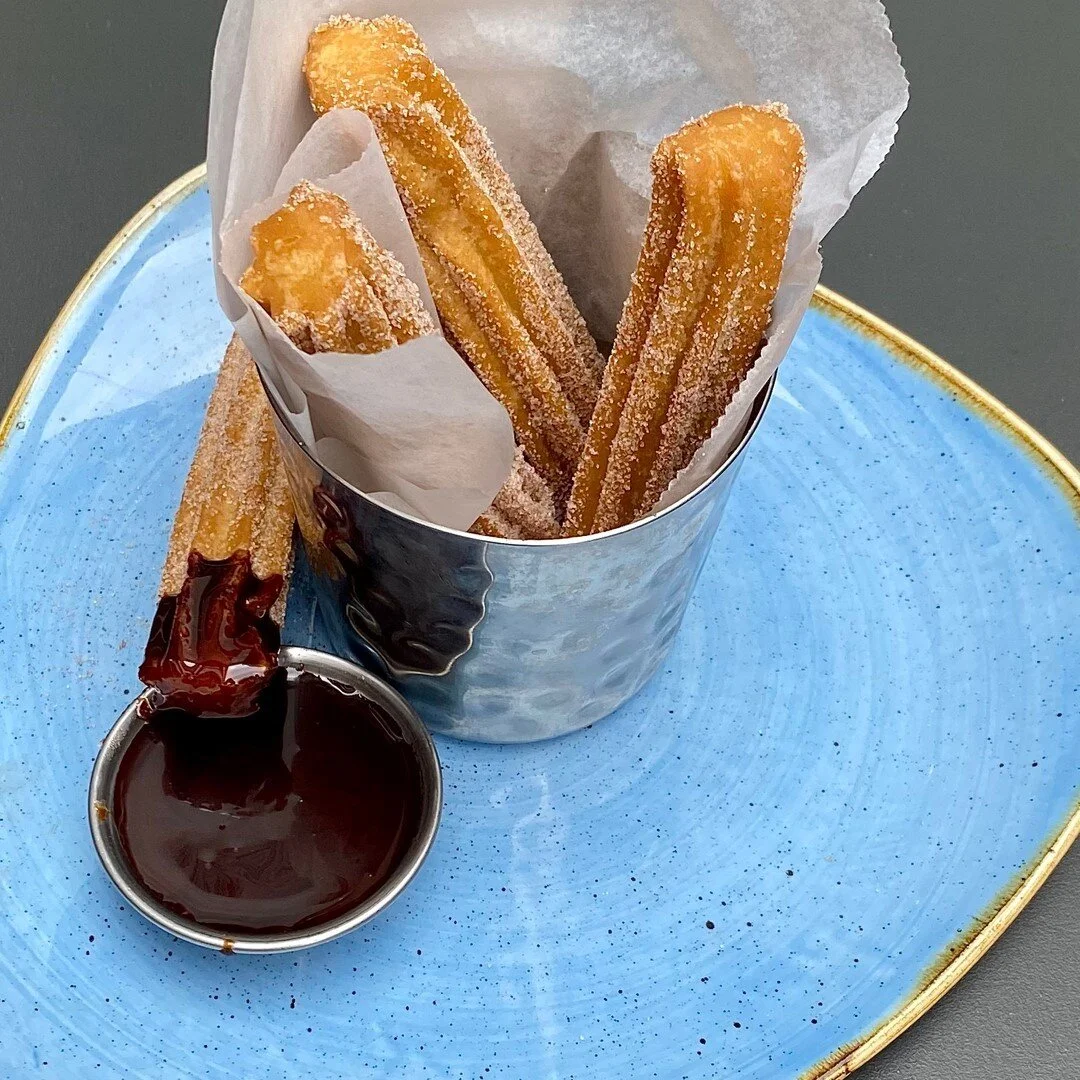 Warm churros covered in cinnamon and sugar dipped in chocolate goodness.