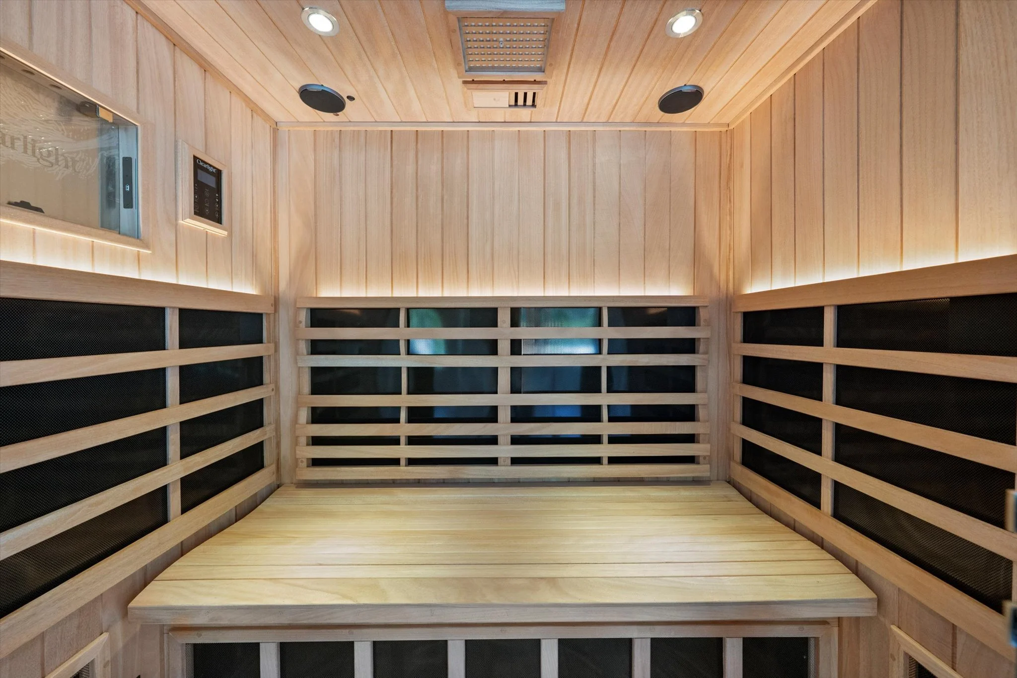 Interior of a wooden sauna room with benches and ceiling lights.