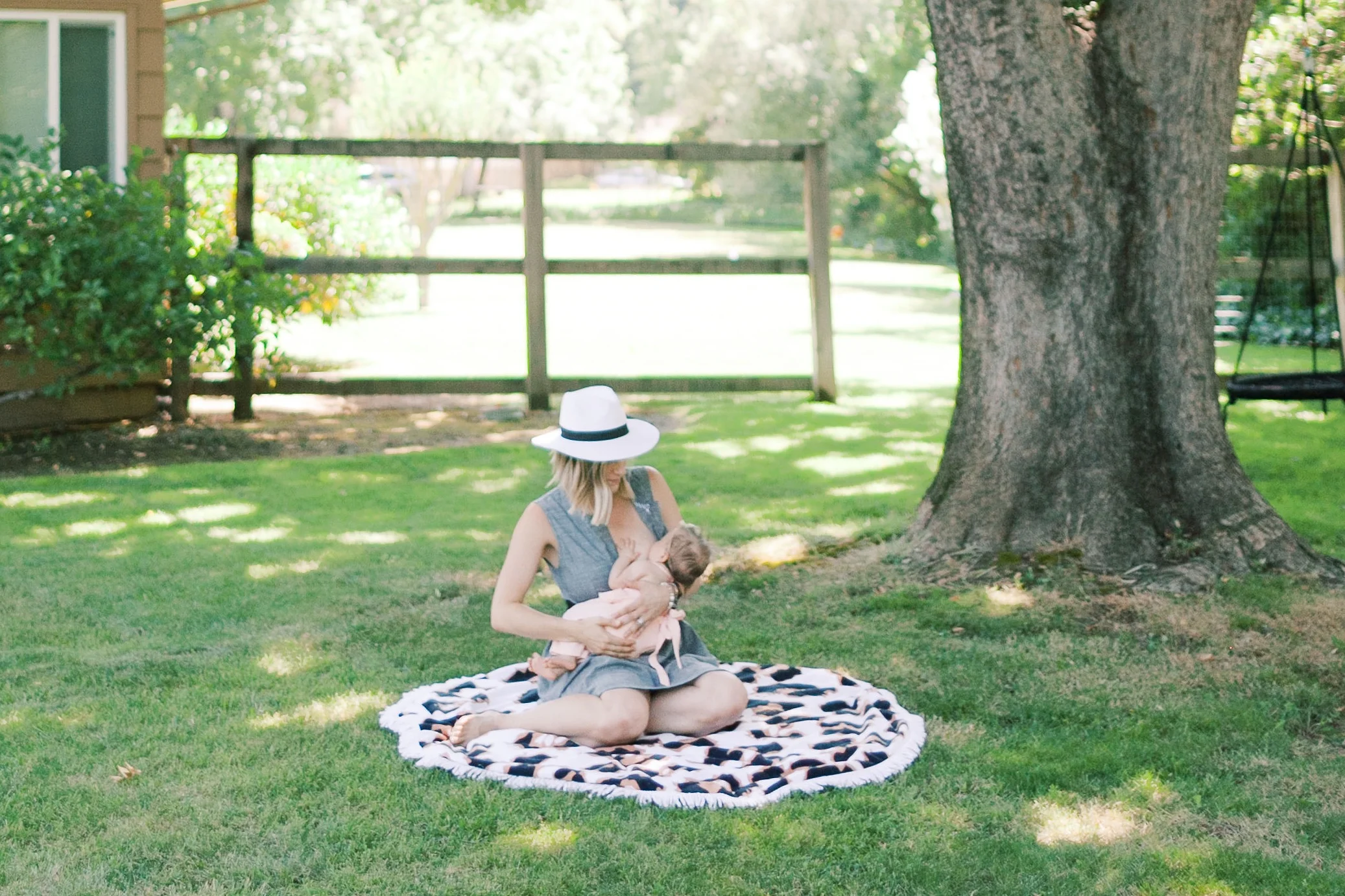 A mother wearing Layton’s Suki dress while breastfeeding her baby.