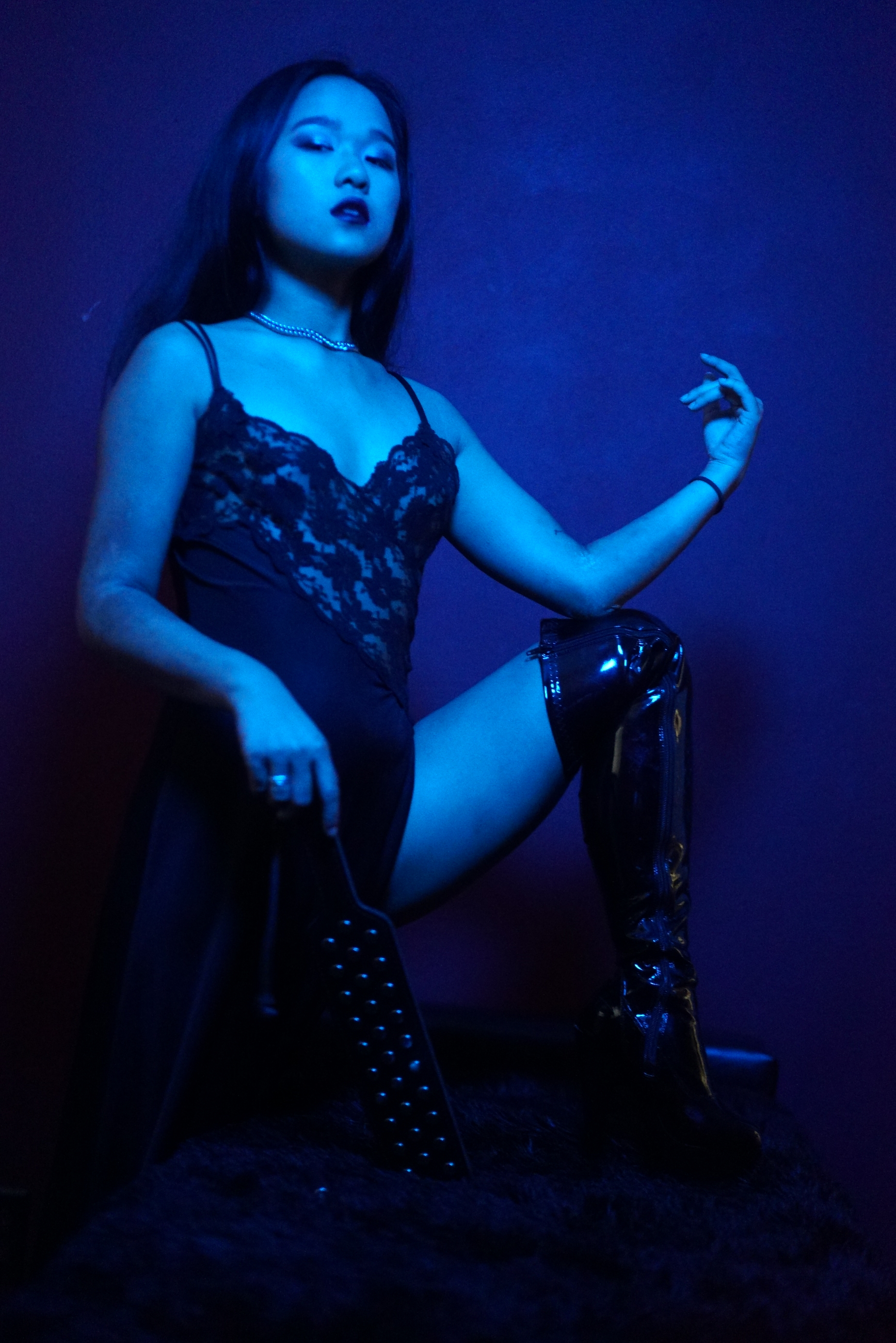 Asian New York professional dominatrix Empress Wu holding the impact tool she most prefers for doling out torture