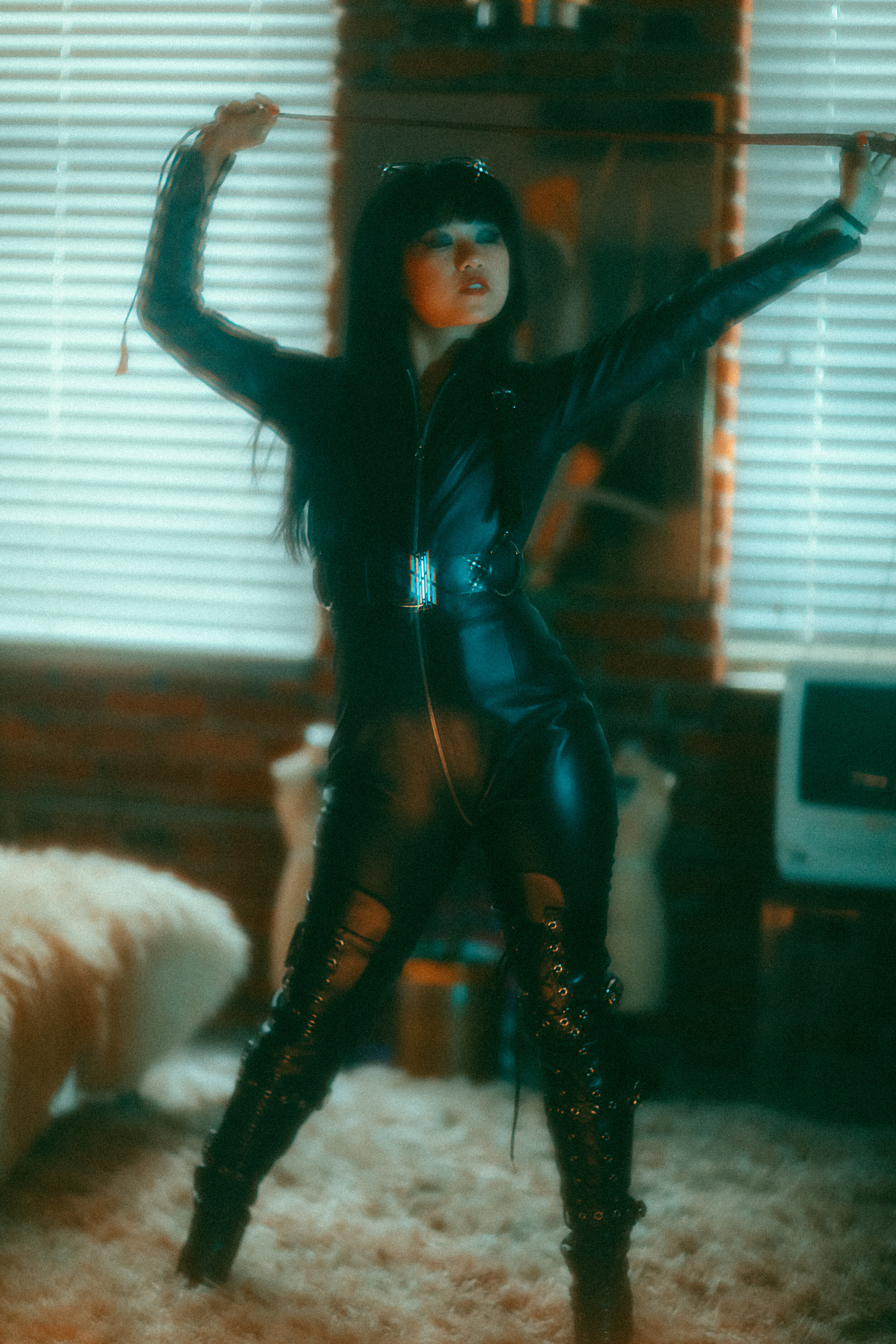  Asian nyc dominatrix empress Wu in leather catsuit and leather boots holding her whip 