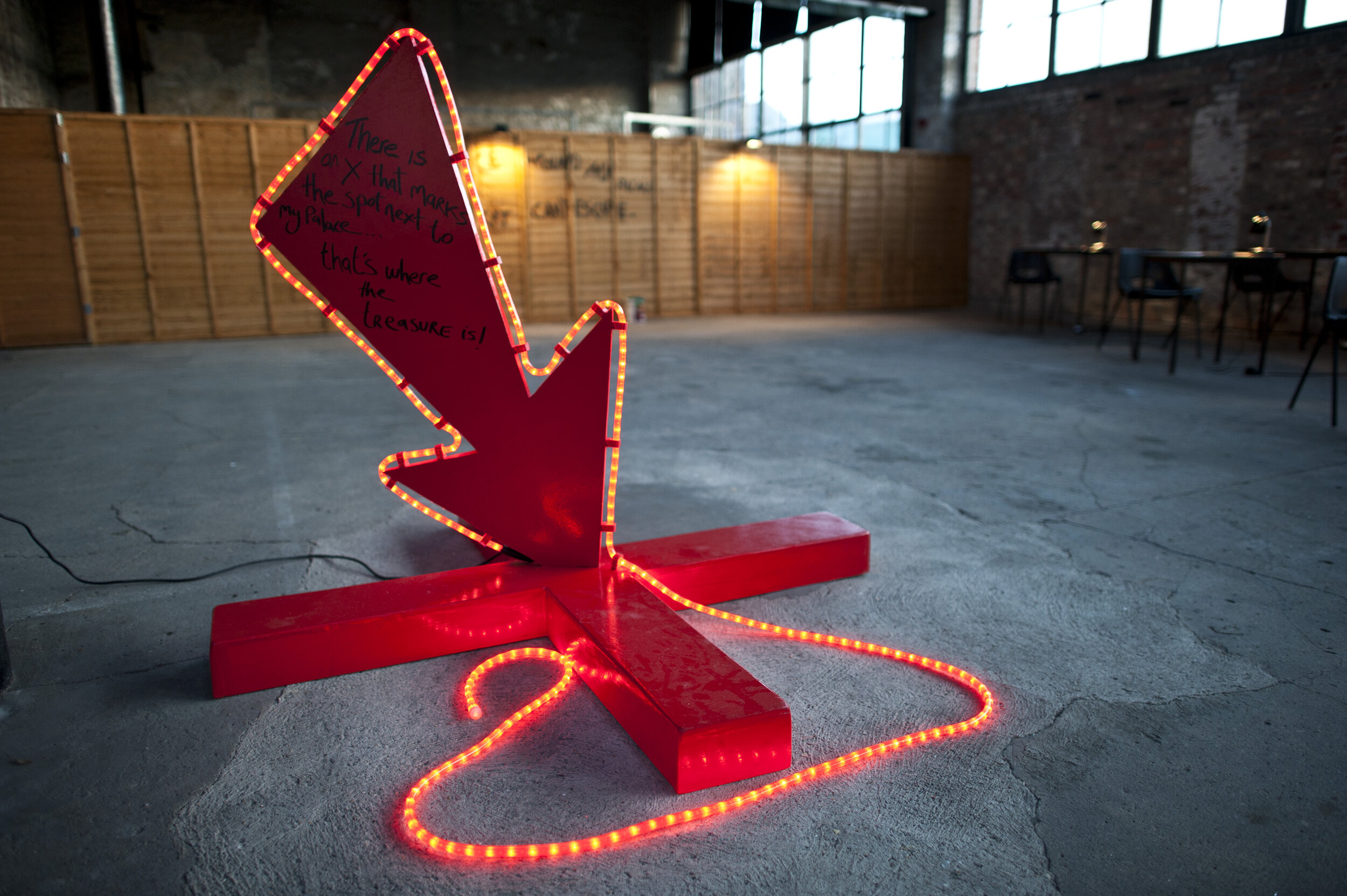  a large red arrow points to an X marked on the floor. 