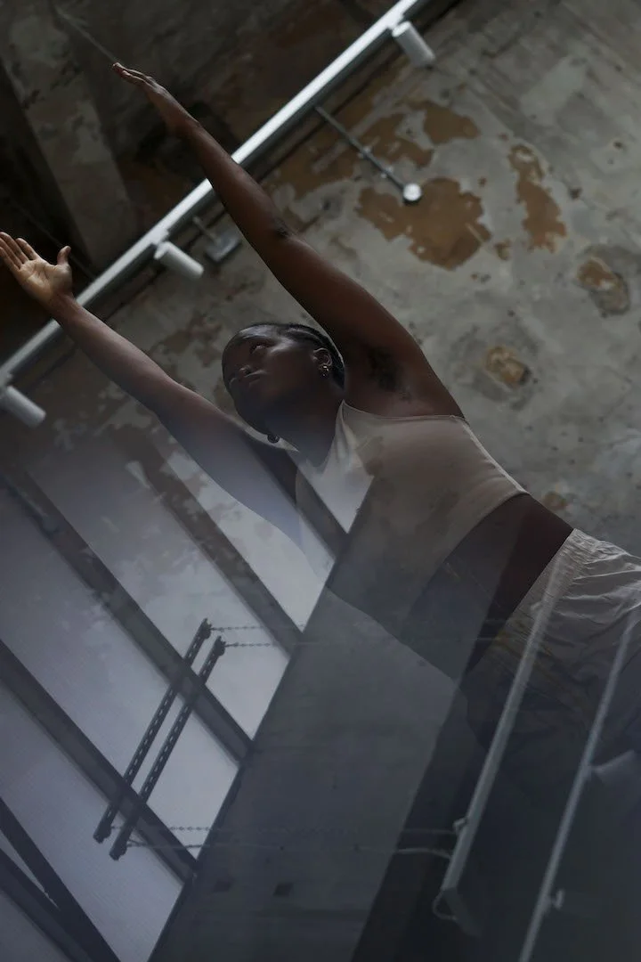 n:u with their arms raised in a pose similar to a sun salutation.