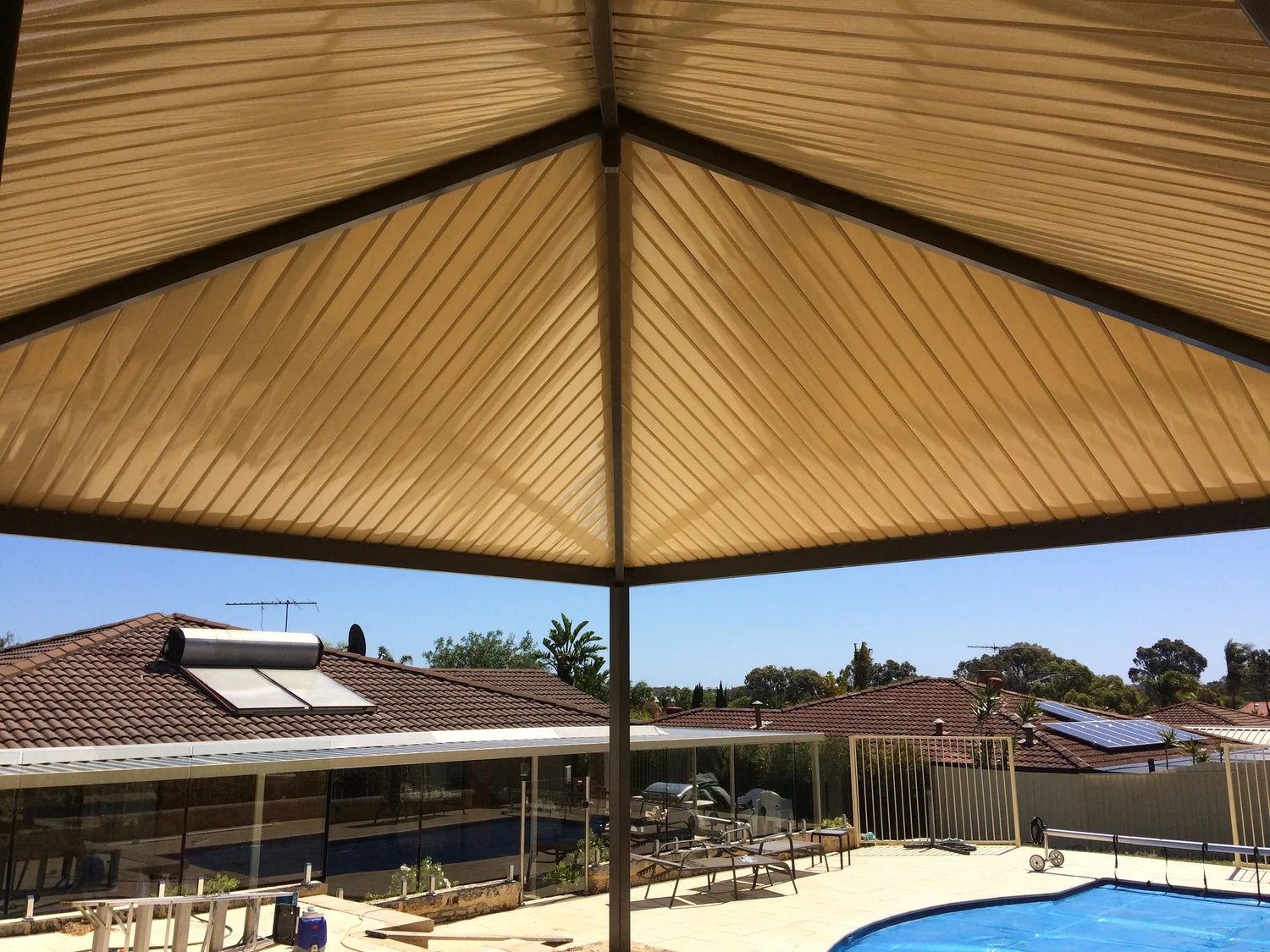 Shade structure beside a backyard swimming pool