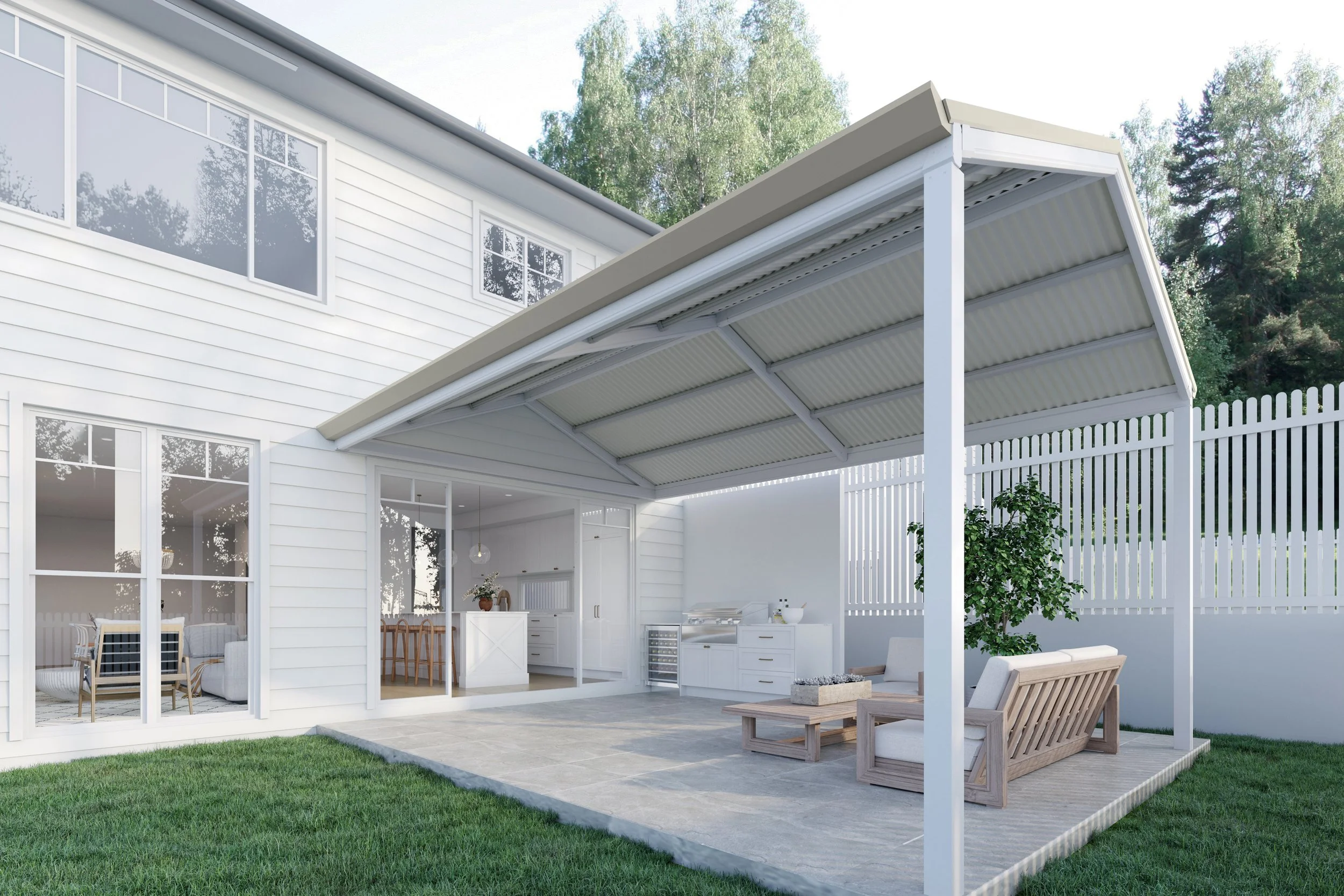 Modern backyard with a white house featuring large windows and a covered outdoor patio area with seating and dining furniture, surrounded by a white fence and lush green trees in the background.