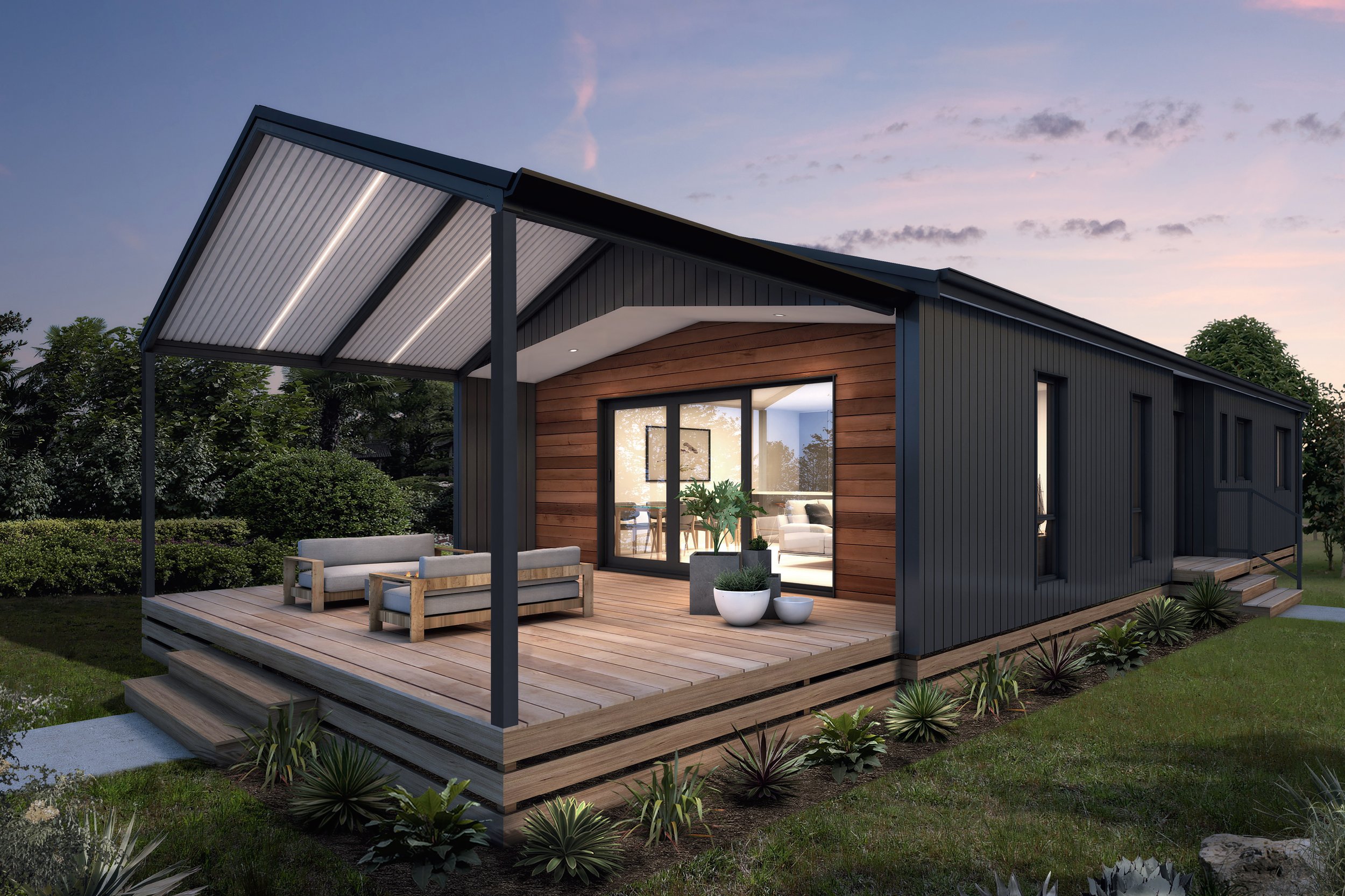 Modern house with a wooden deck and outdoor seating, featuring large windows and a covered patio, surrounded by landscaped greenery at dusk.