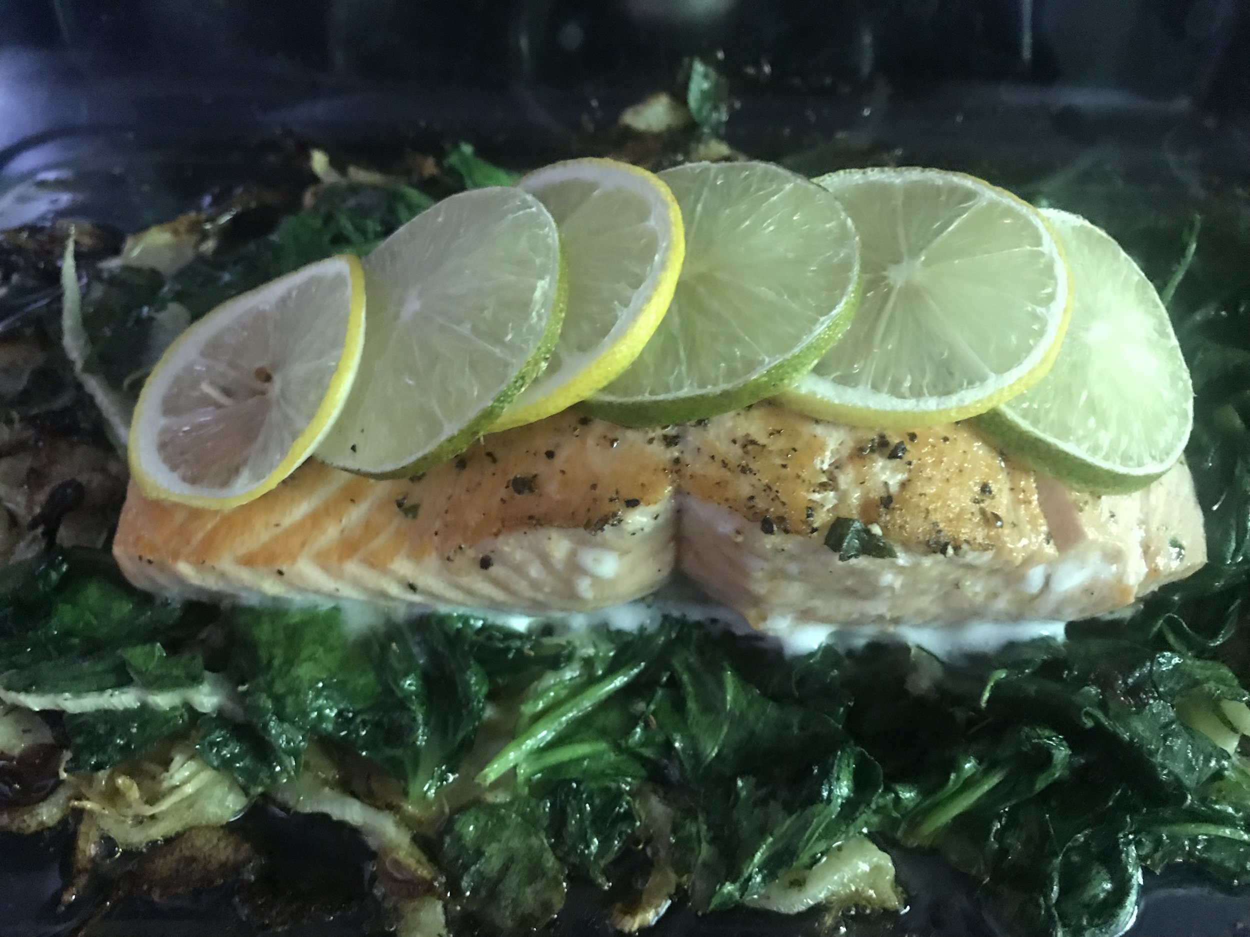  Salmon with citrus marinade pan seared on a bed or power greens and mushrooms.  
