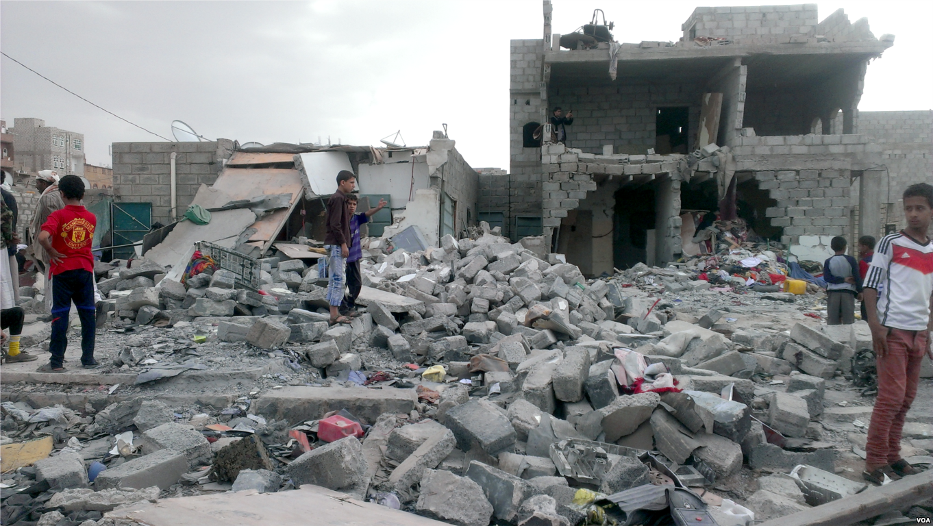 Yemeni children stand in the aftermath of an airstrike in Sana’a in 2015. (Wikimedia Commons)