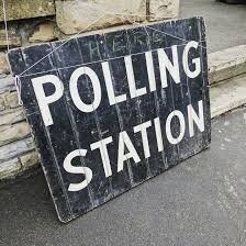A polling station sign left on the ground (Pixabay).