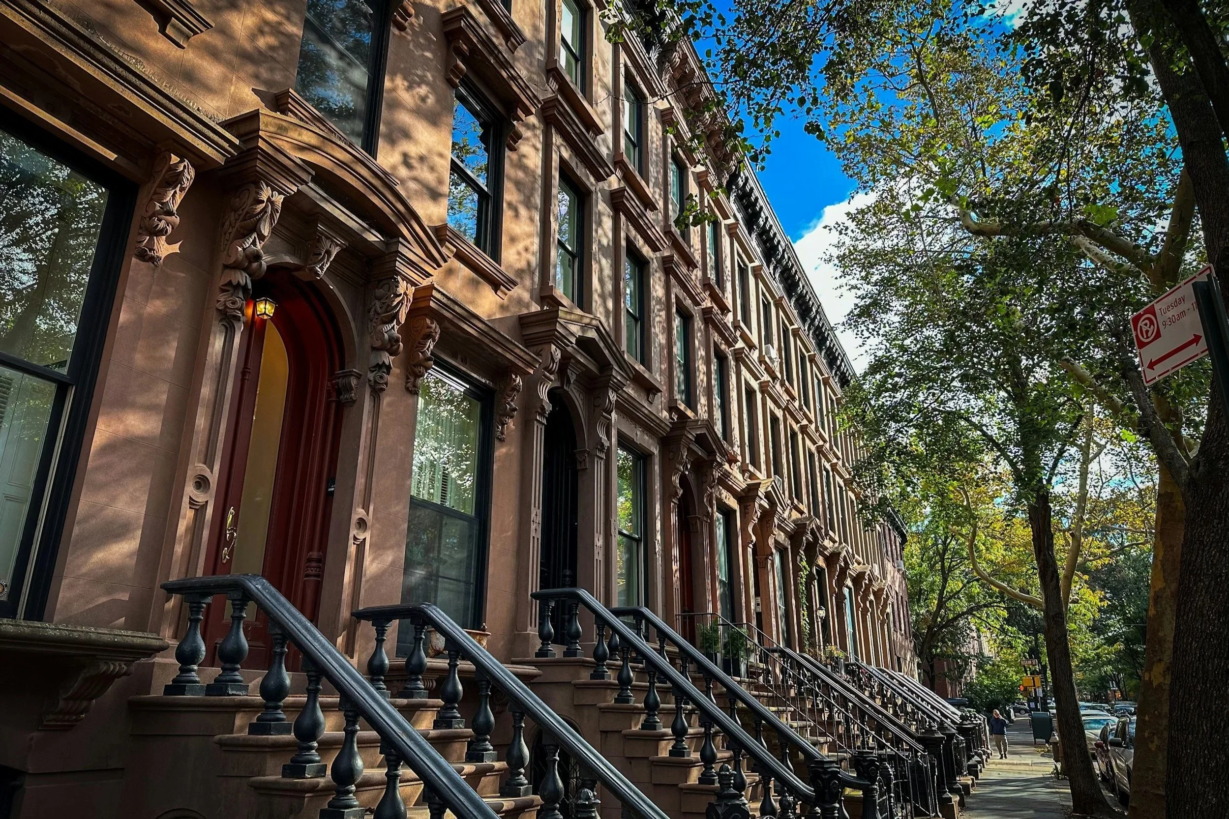 Row of brownstone townhouses on a tree-lined New York City street