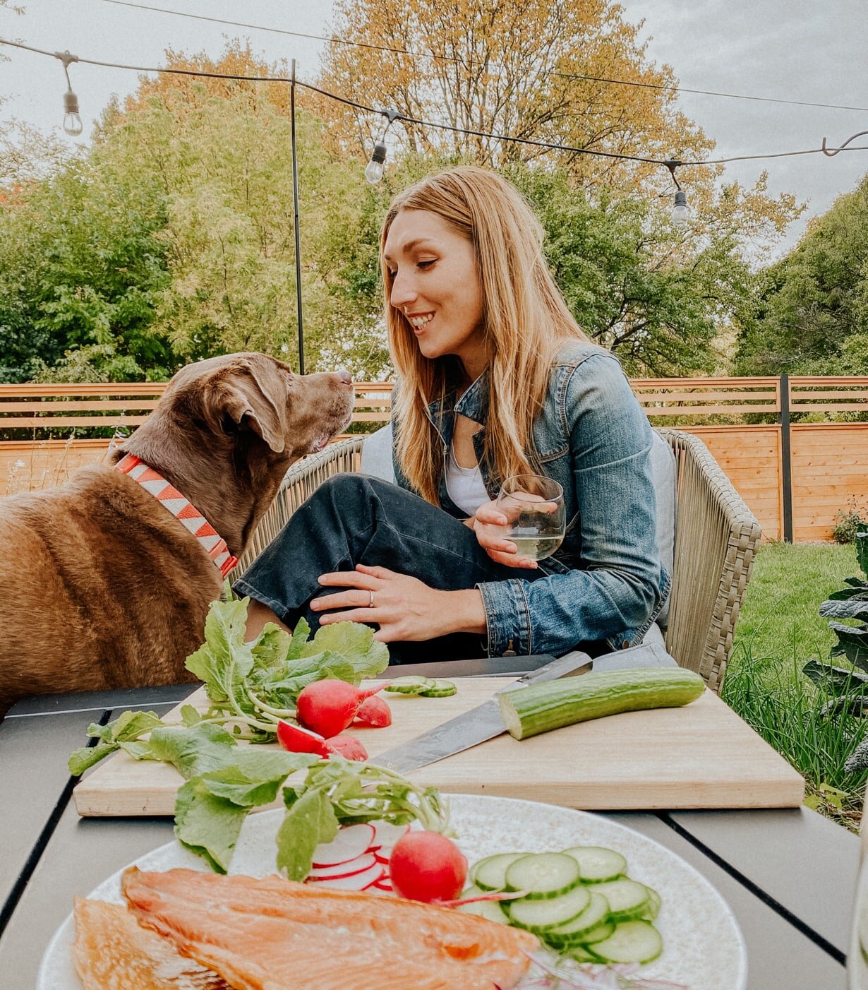 Micaela grazing outside with her chocolate lab, Charlie.