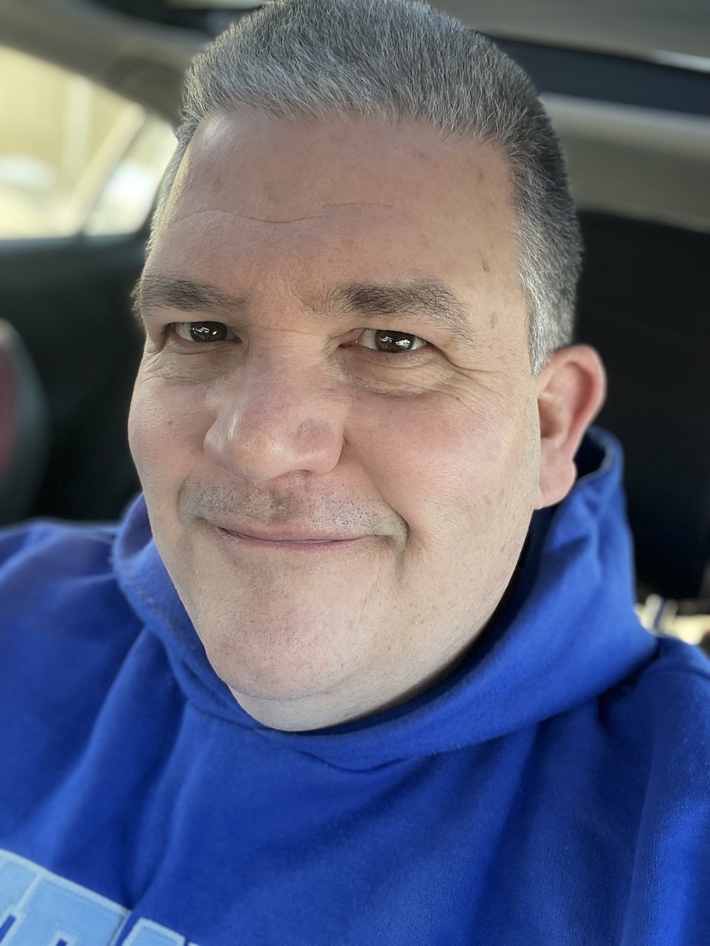 CC Chapman smiles at the camera wearing a blue hoodie