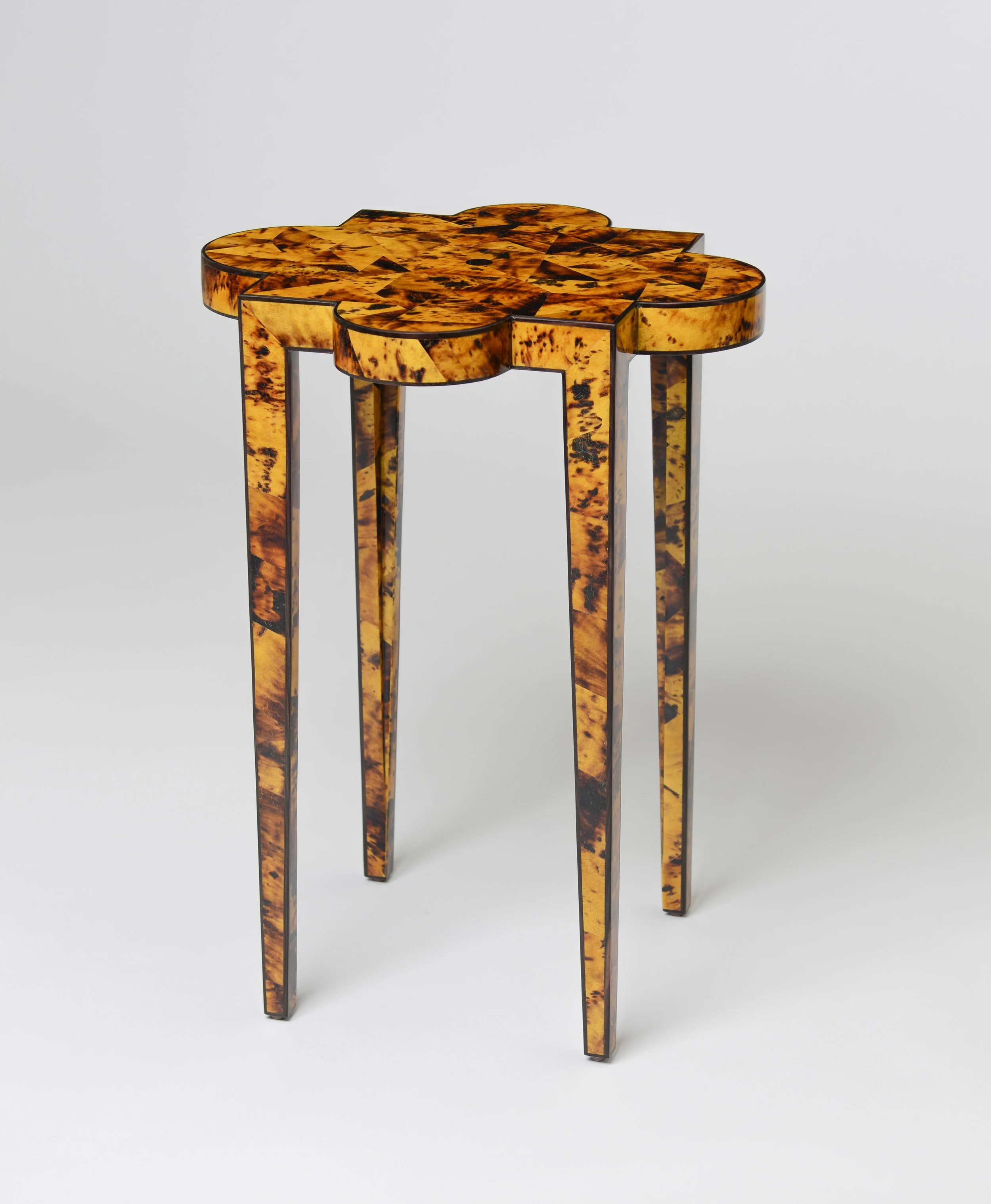 Front view of the Lani Table in Amber Pen Shell with ebony trim