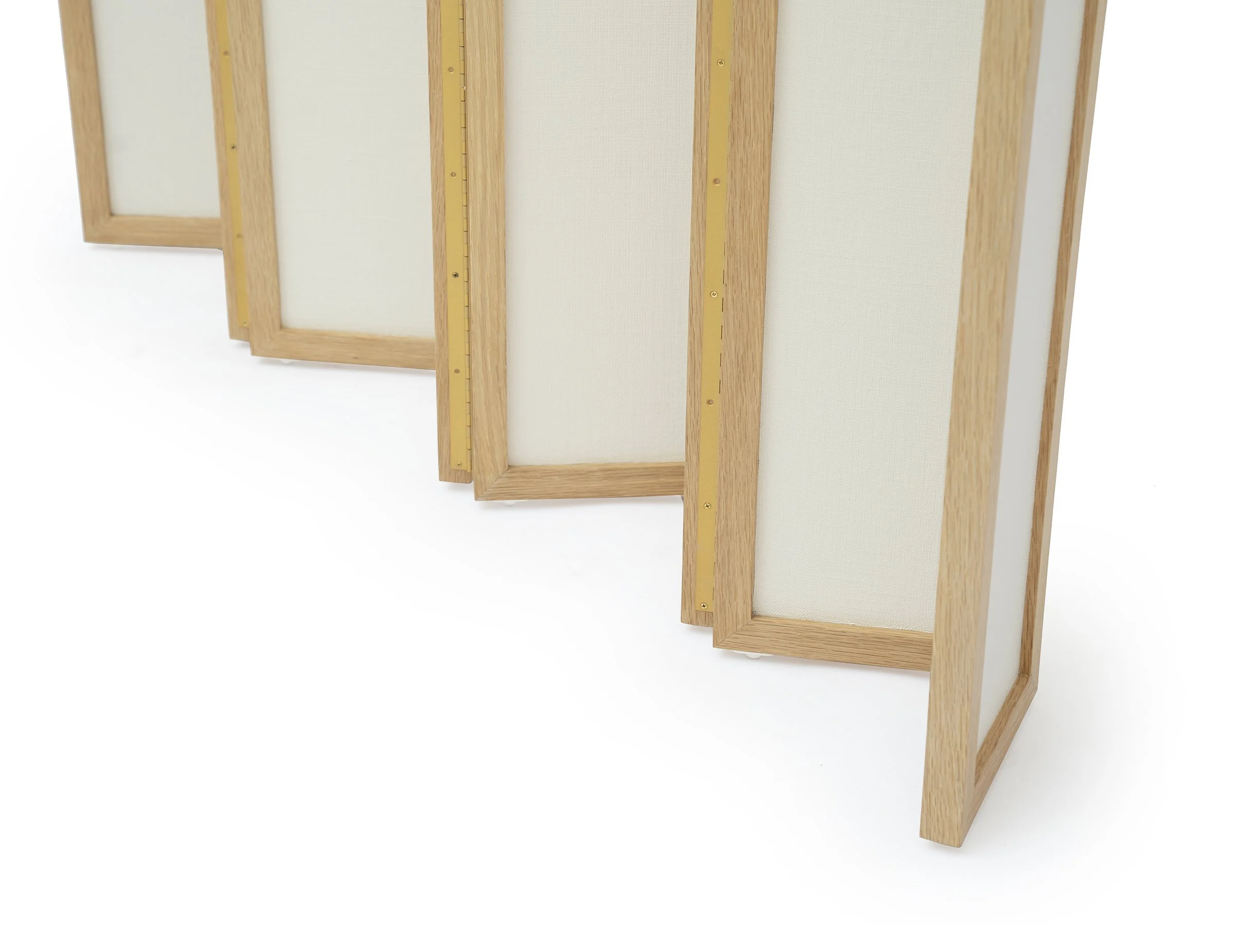 Detail view of brass piano hinges and lacquered linen texture on Christine Screen.