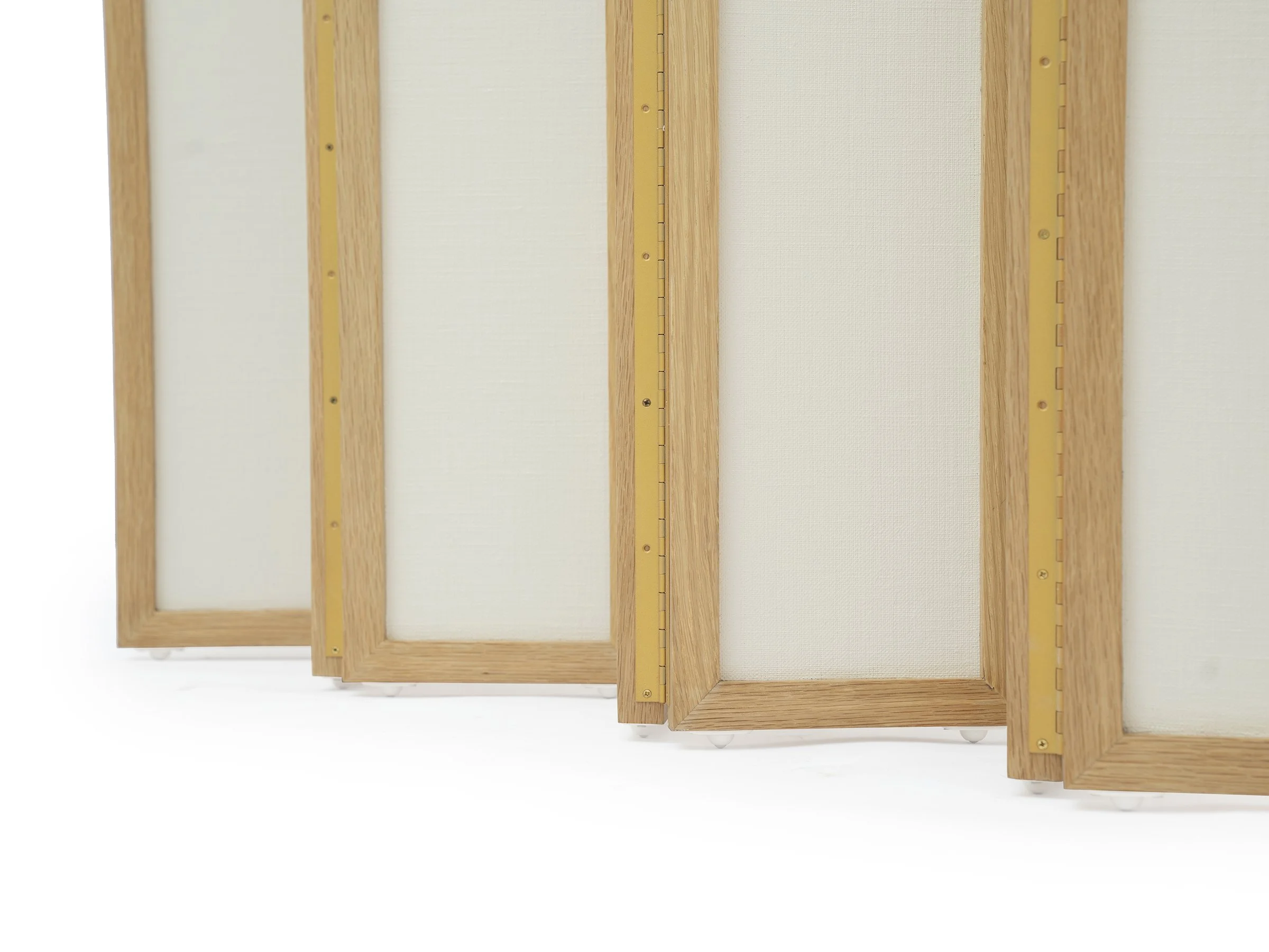 Detail view of brass piano hinges and lacquered linen texture on Christine Screen.