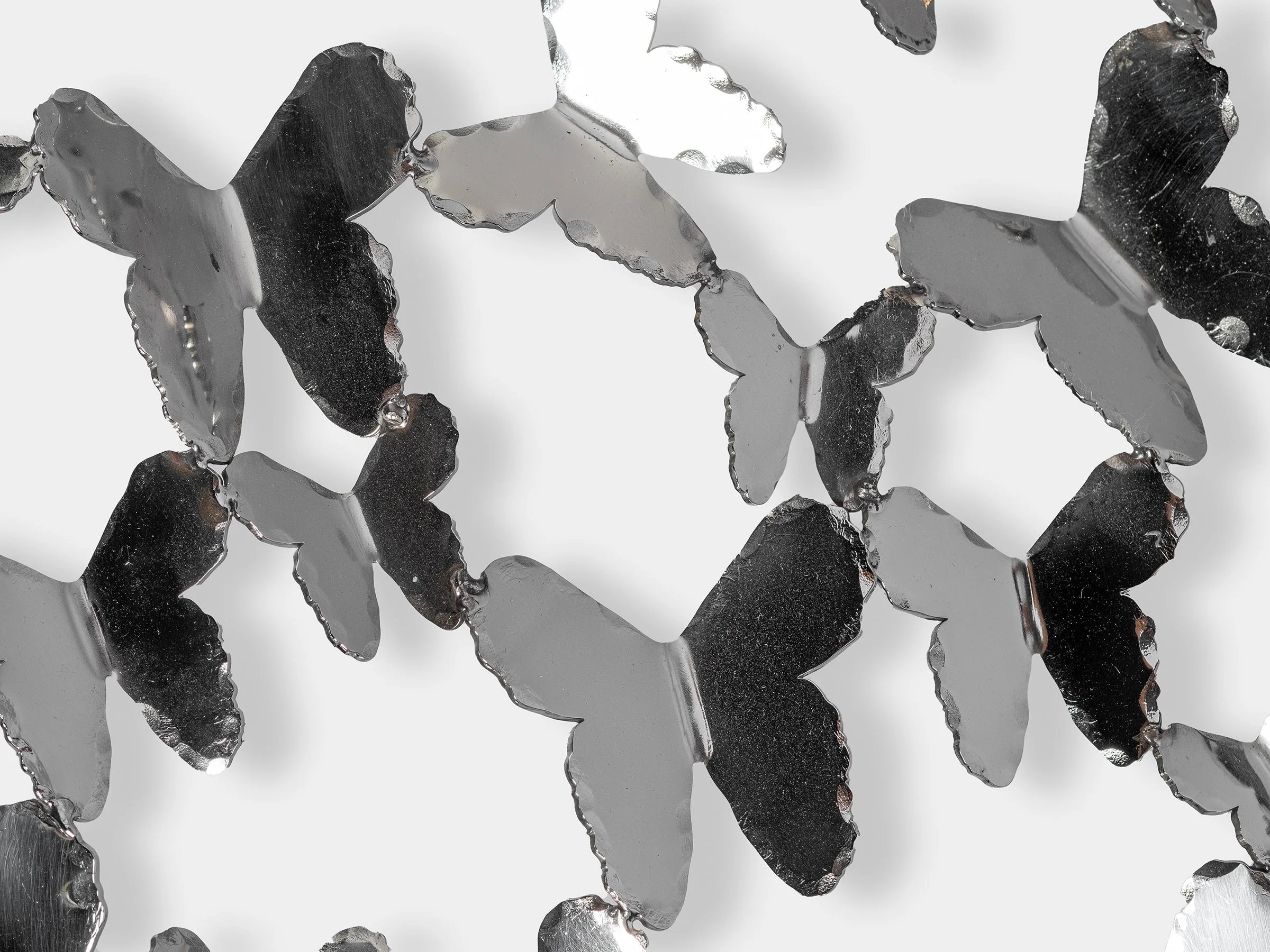 Close-up detail of hand-cut mirrored butterflies forming the screen.
