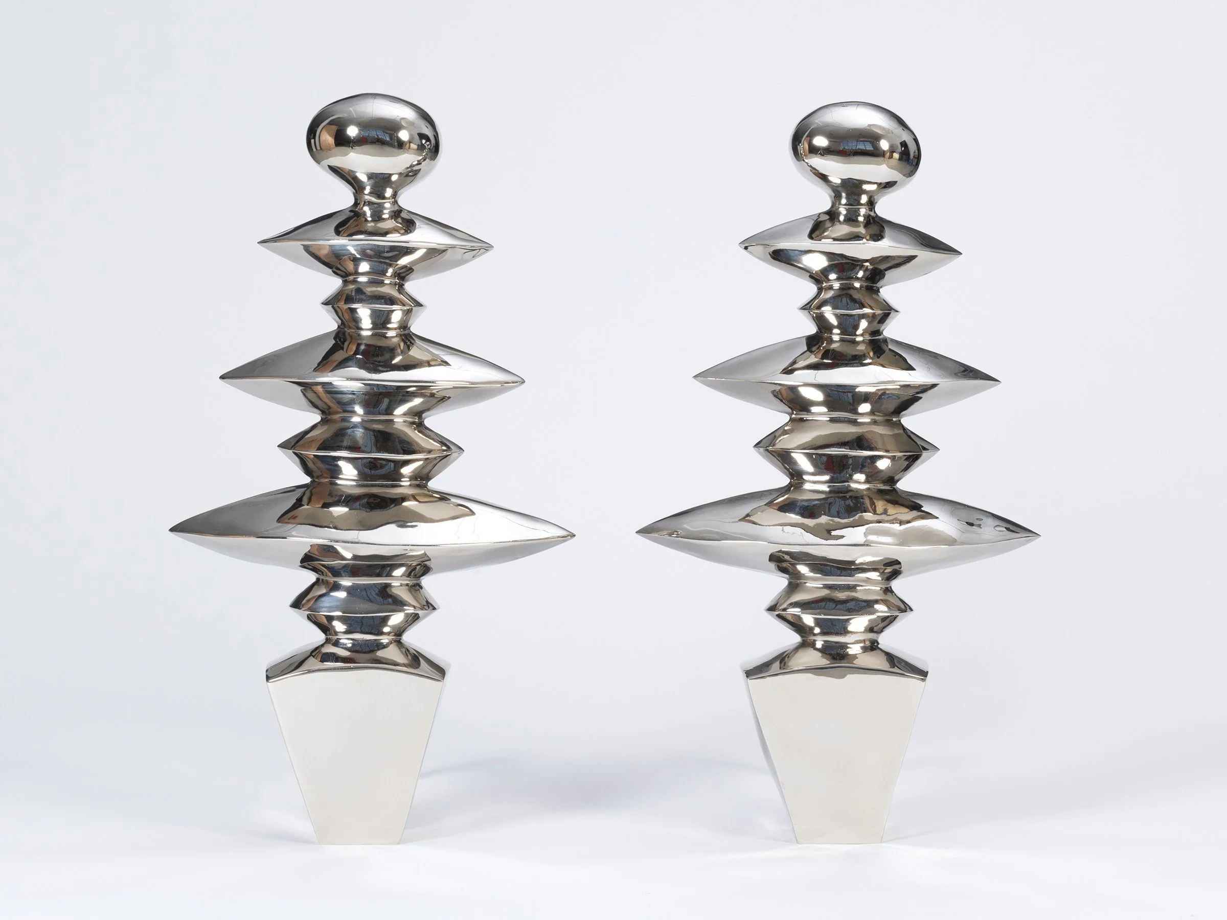 Zig Zag Colossus andirons in polished white bronze, front view.