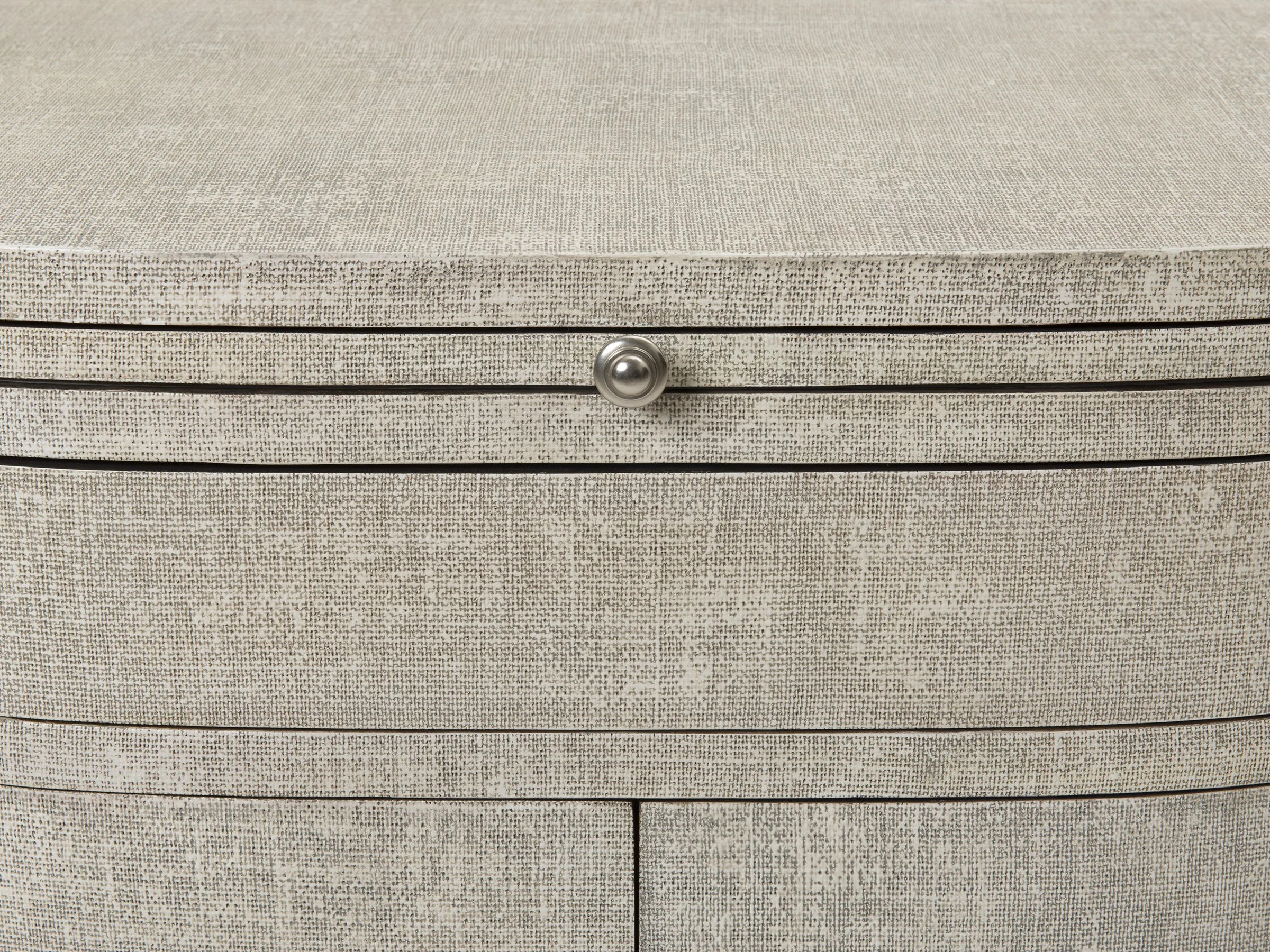 Detail view of The Rita Cabinet in Snow lacquered linen showing bronze knob and linen texture