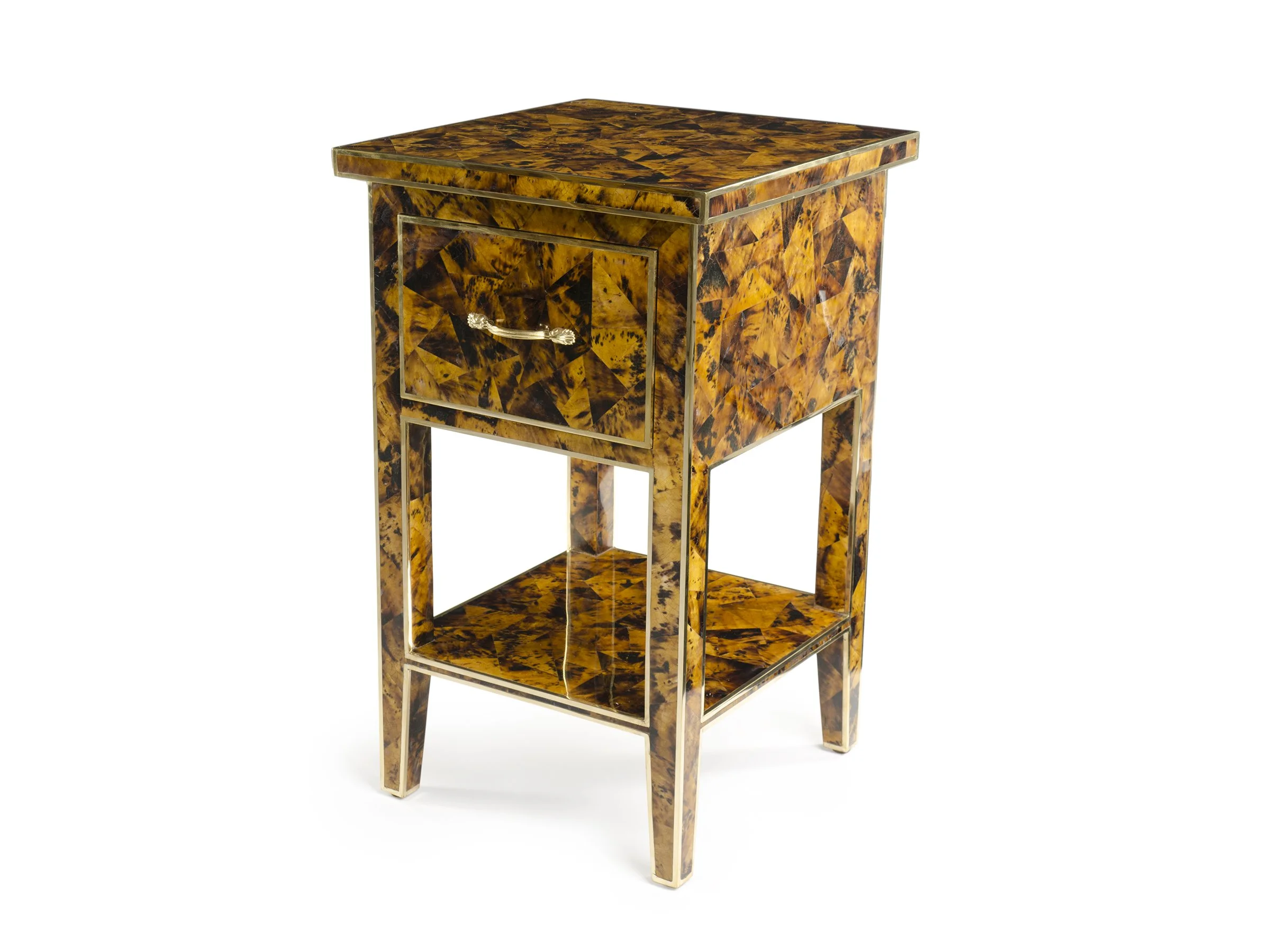 Angled view of the Manor Nightstand in amber pen shell with gold leaf trim, highlighting the drawer, shelf, and tapered legs.