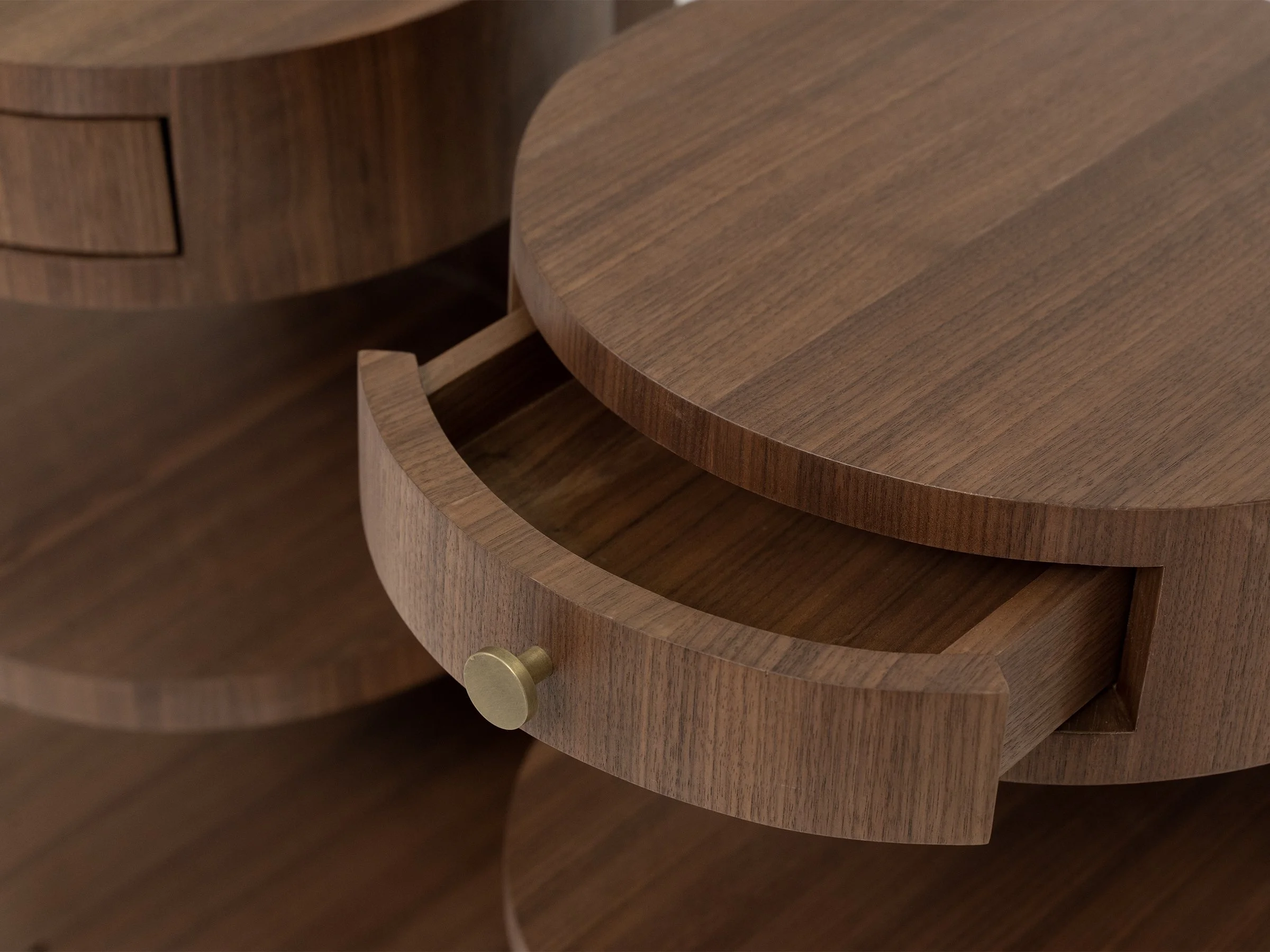Aram Stand shown in natural walnut with antique bronze knob, teardrop-shaped with a single drawer and two round shelves. Detail