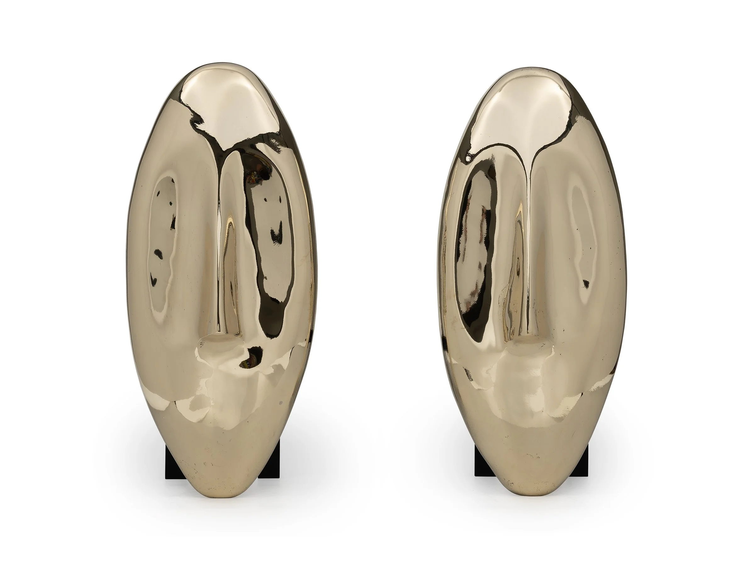 Front view of Face Andirons in polished bronze with abstract facial form