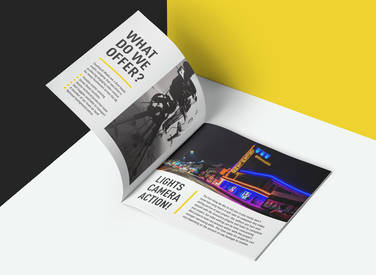 Open magazine with black and white photo of camera equipment and colorful neon-lit amusement park rides, on a background with black, white, and yellow sections.