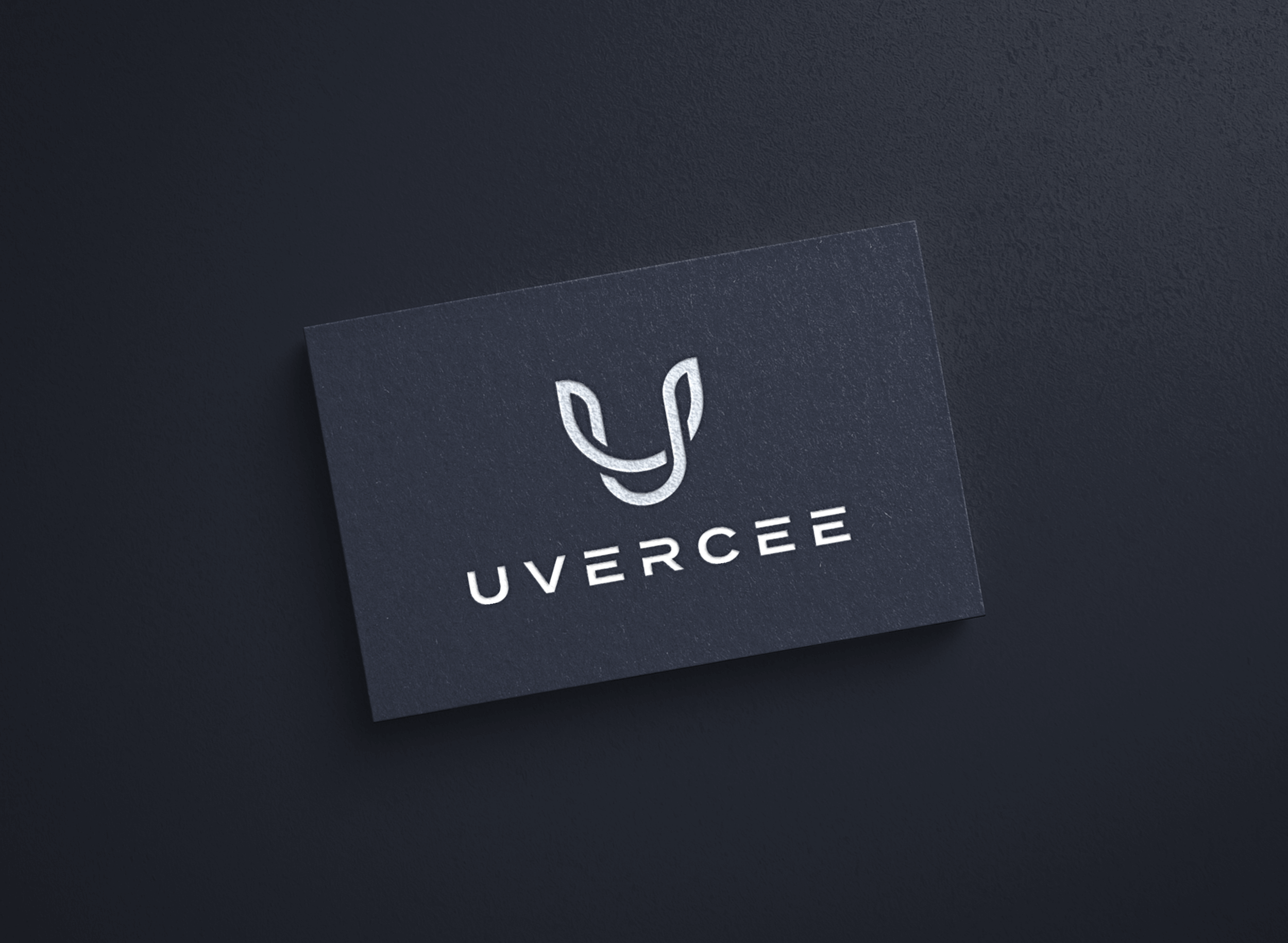 Black business card with a white abstract logo and the text 'UVERCEE' on a dark surface.