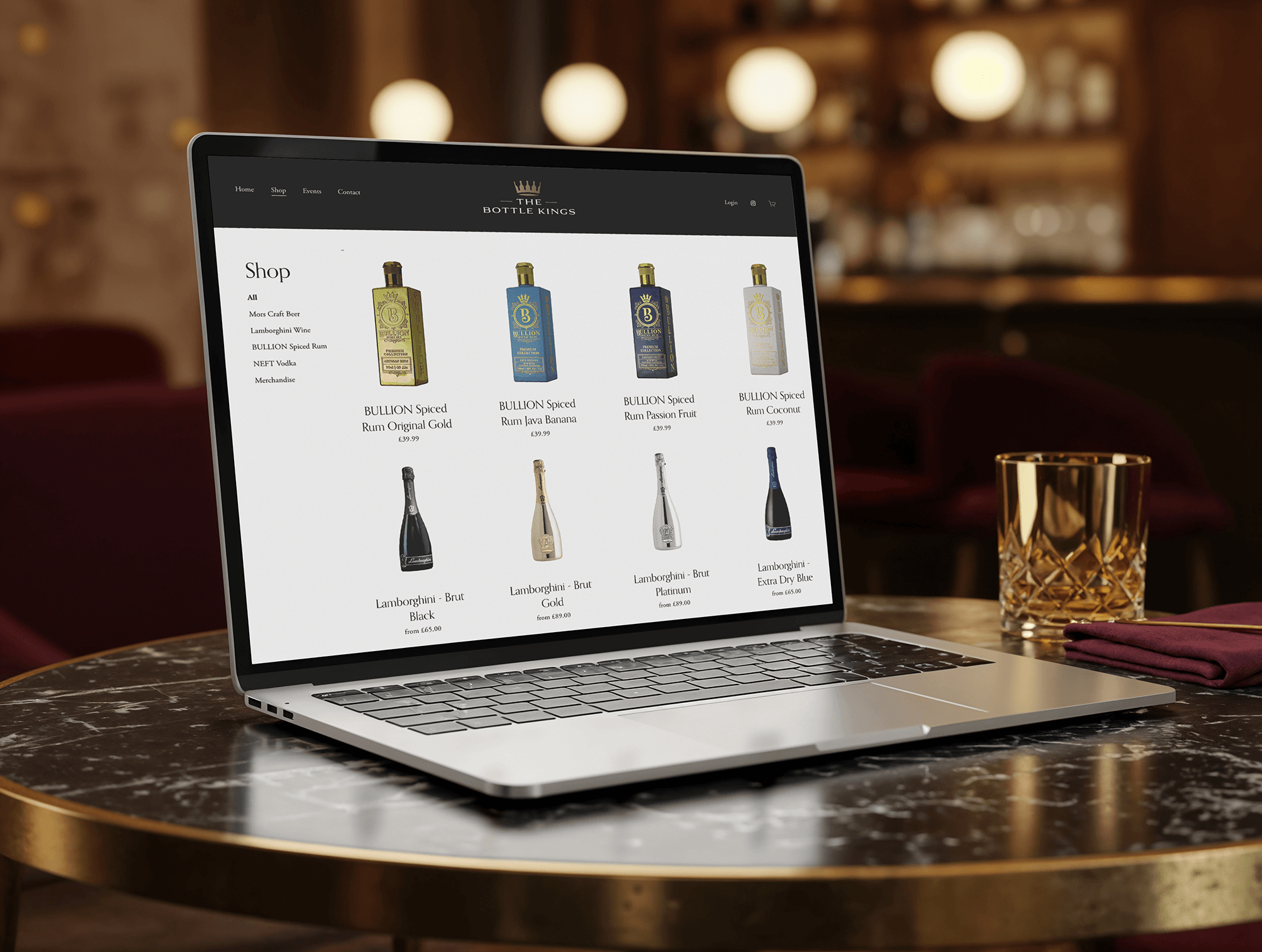 Laptop on a marble table showing an online shop for bottles of spirits with various brands and prices.