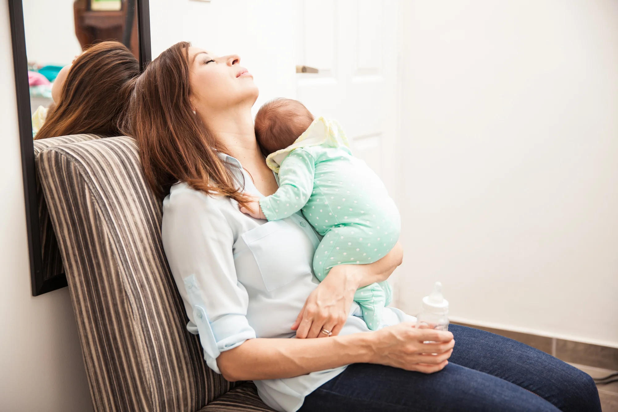 Tired mom with her newborn baby