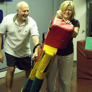 Vinny "Whatever the Case" Spakowski joined Modern Warrior in 1995, and earned his black belt in 2005. For a decade, he has been lead instructor for our Silverbacks program. Having assisted with martial arts classes, Police Defensive Tactics and Female Self Defense courses, he says suiting up as a bad guy is "one heck of an experience!" A prominent training memory for him is having stayed up with his classmates for 72 straight hours of intense training at Kung Fu Weekend. Vin in a nutshell: a 40 year marriage, two children, two grandchildren…and an array of suits that are the envy of Long Island.