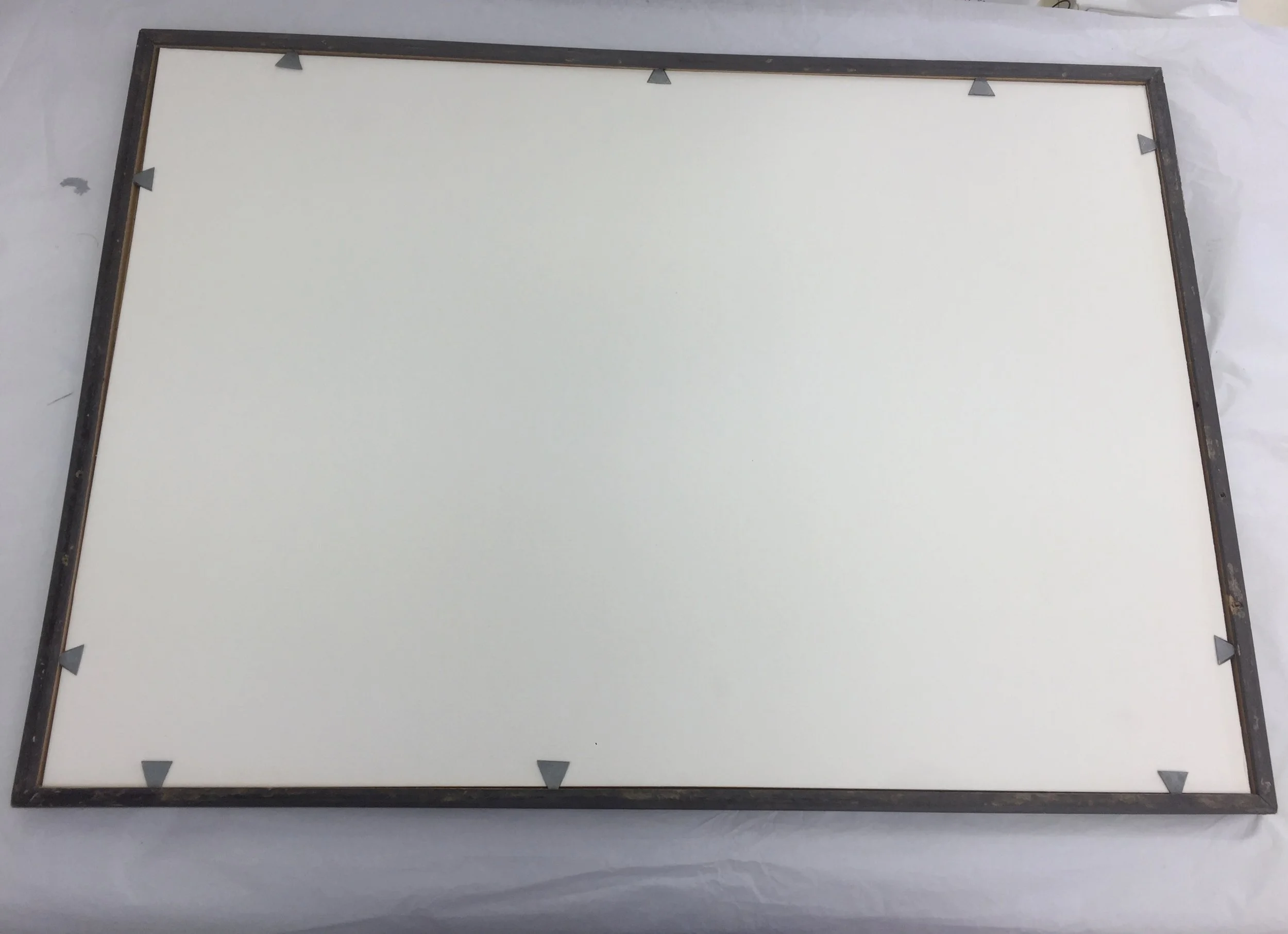  After bonding, repairs to the paint were applied to a separate sheet of clear polyester archival sheeting. This sheet was placed behind the glass. The object was then remounted in the original frame with archival mounting board and new pins.  