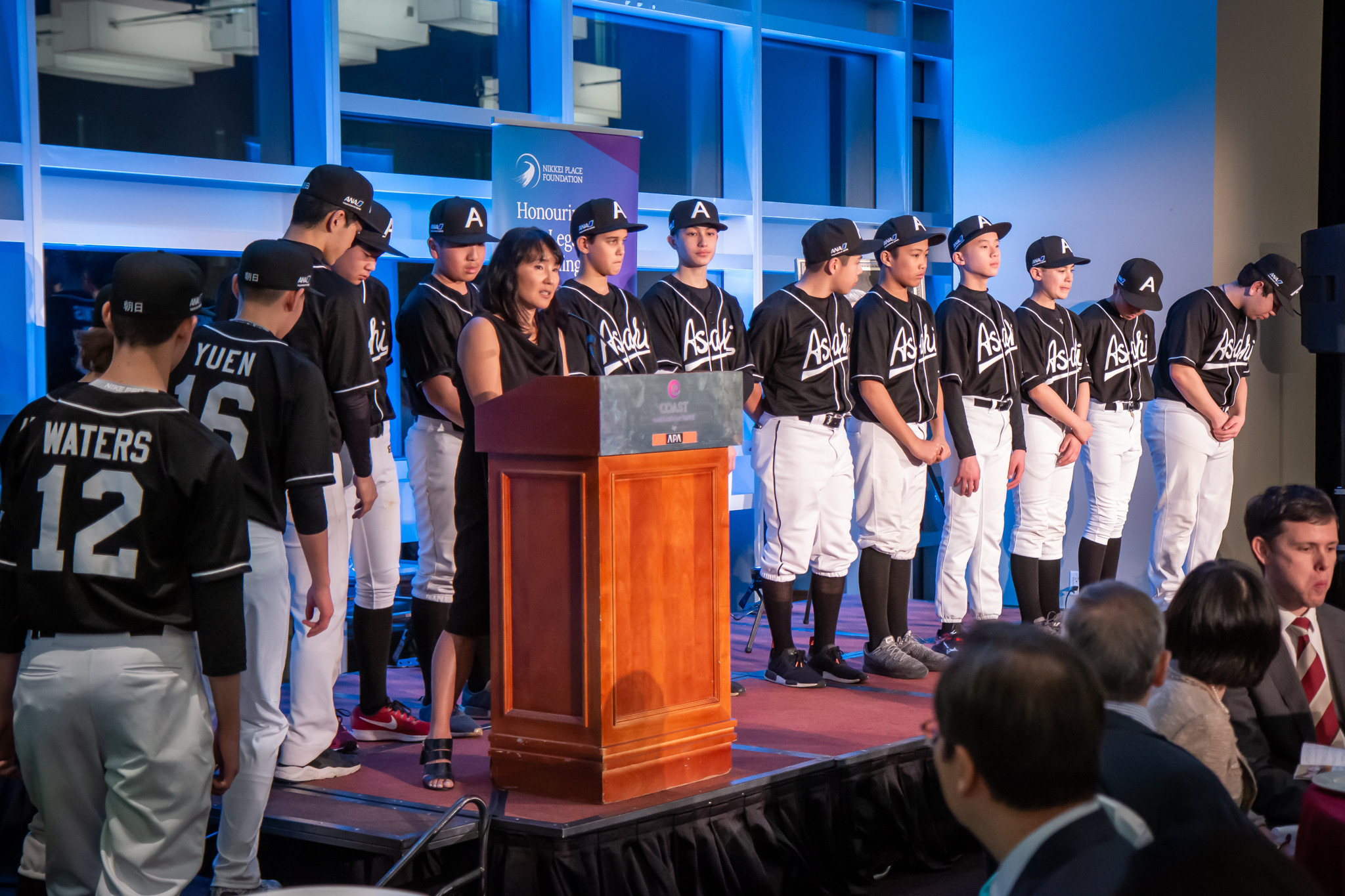 Emiko Ando of the Asahi Baseball Association accepts the Nikkei Youth Athletics Bursary on behalf of the Shin Asahi baseball team.