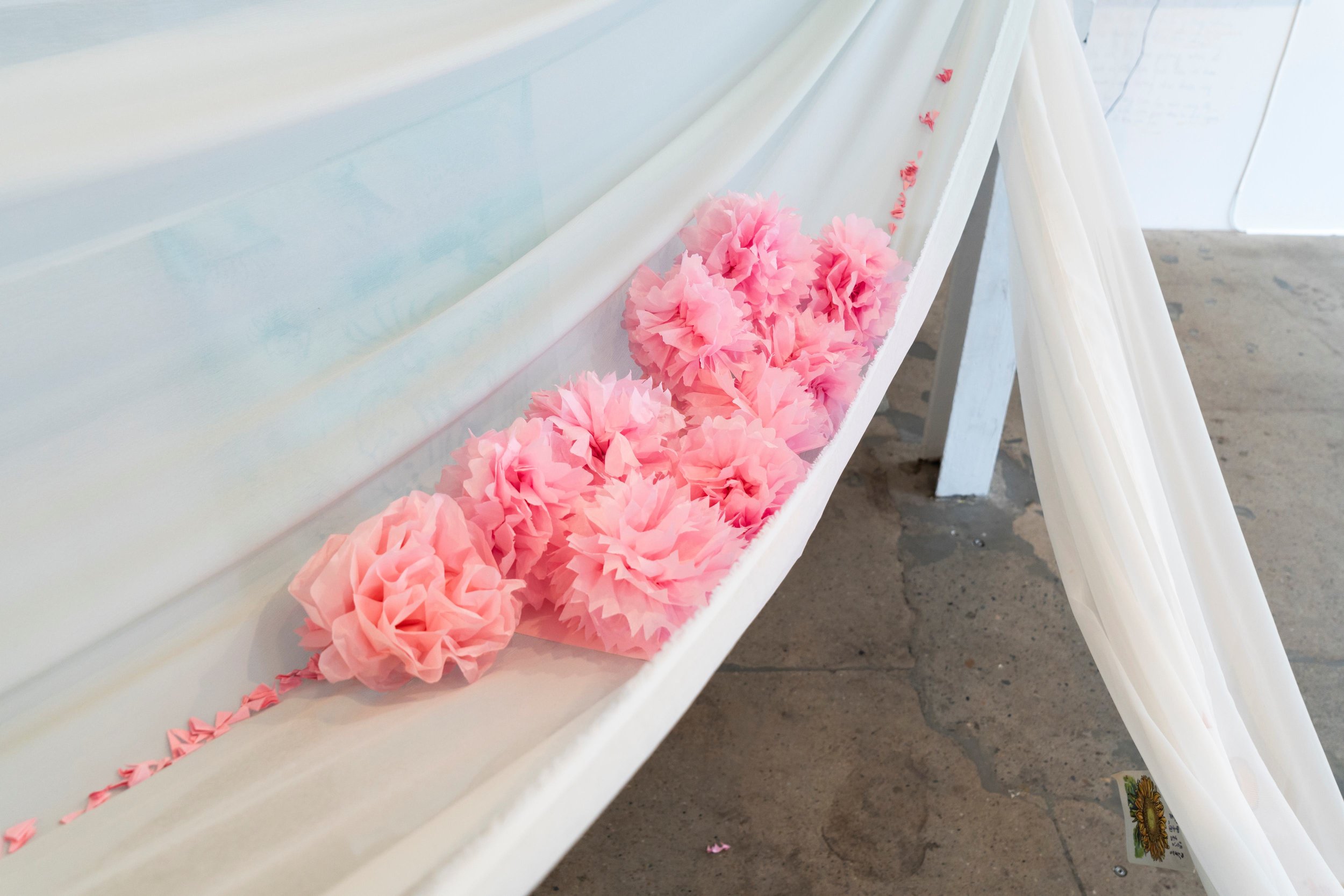   Postcards between the Takeuchis , 2021-2023. Installation, cotton, batik on silk, postcards, kirigami [paper flowers]. Dimensions variable. Photograph by Louis Lim. Courtesy the artist. 