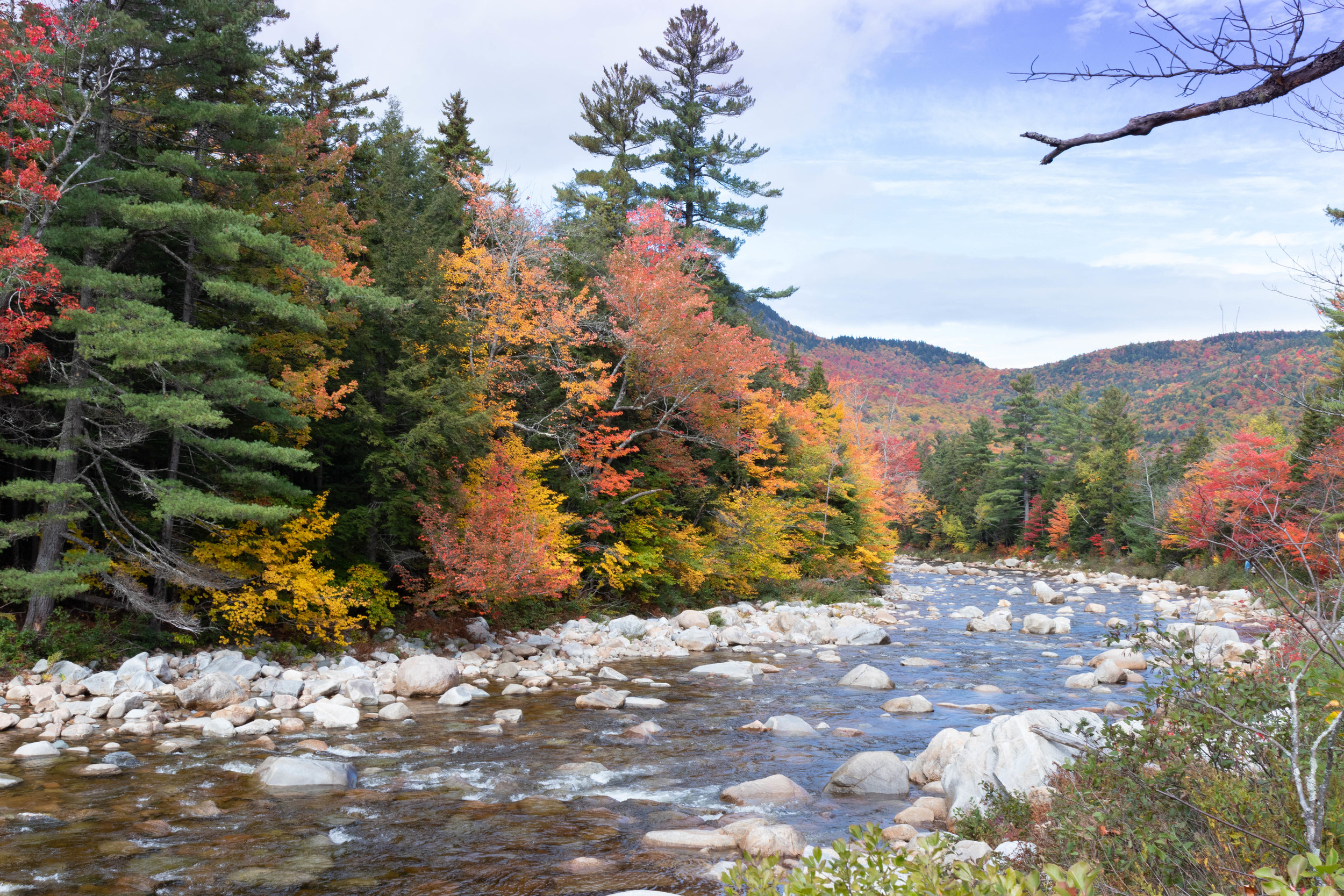Landscape photo of a river along the Kancamagus Highway in North Conway, New Hampshire in fall by Vision Balm in Charleston, SC.