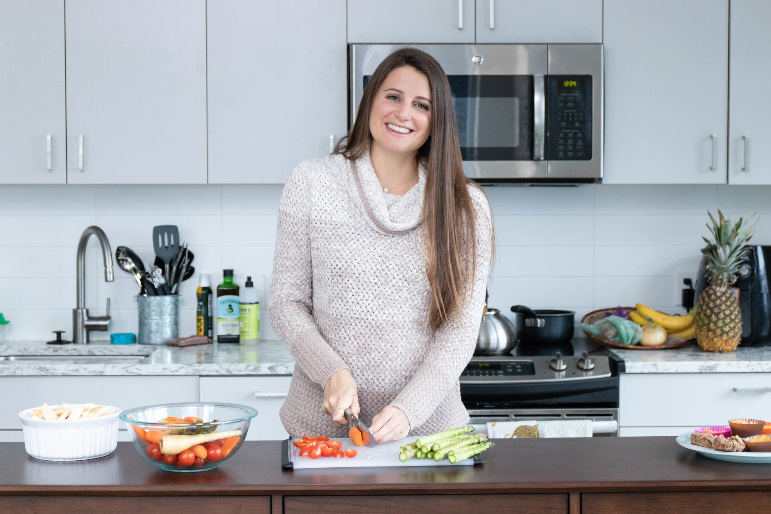 Lifestyle portrait photography of Erin Kenney from Nutrition Rewired registered dieititan chopping vegetables in her kitchen photographed by Vision Balm in Charleston, SC.