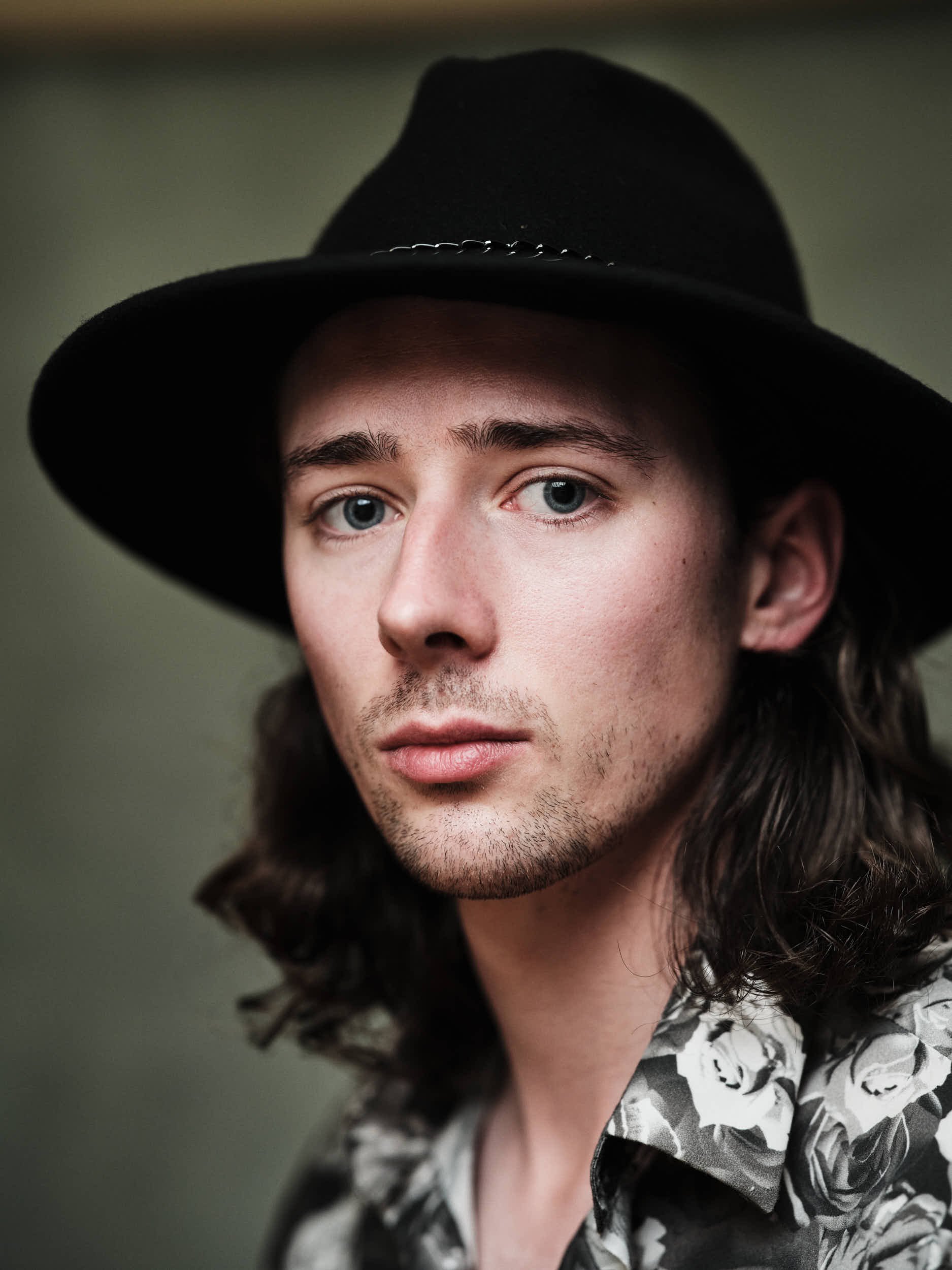 a portrait of an actor wearing a hat