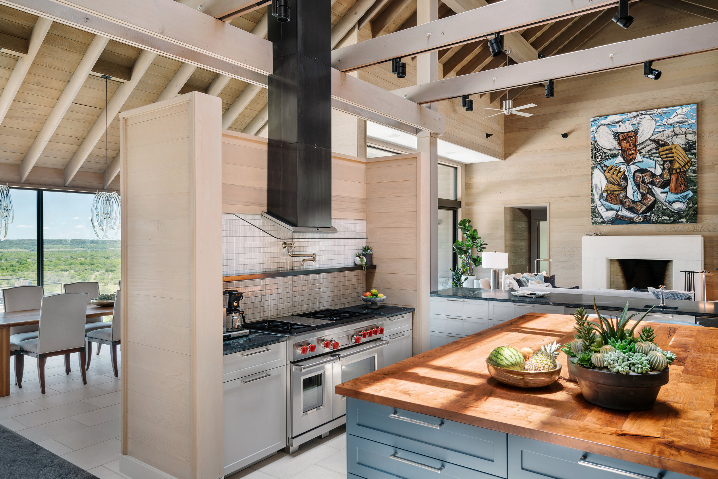 Open-concept kitchen in a Lampassas ranch home with a large island, stainless steel appliances, and a dining area with a scenic view.