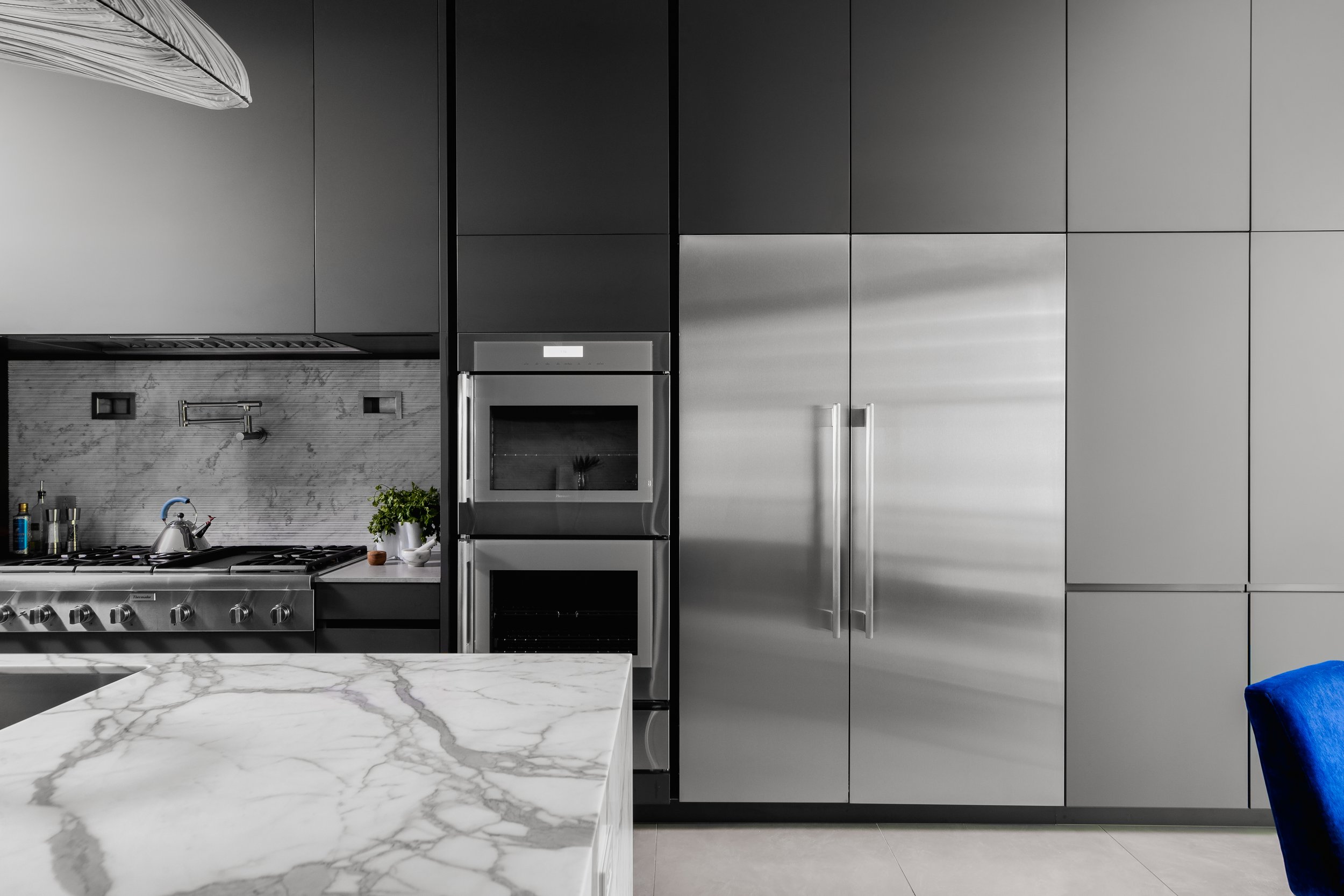 Kitchen in the Mediterranean Modern with stainless steel appliances, matte gray cabinets, and a marble countertop island.