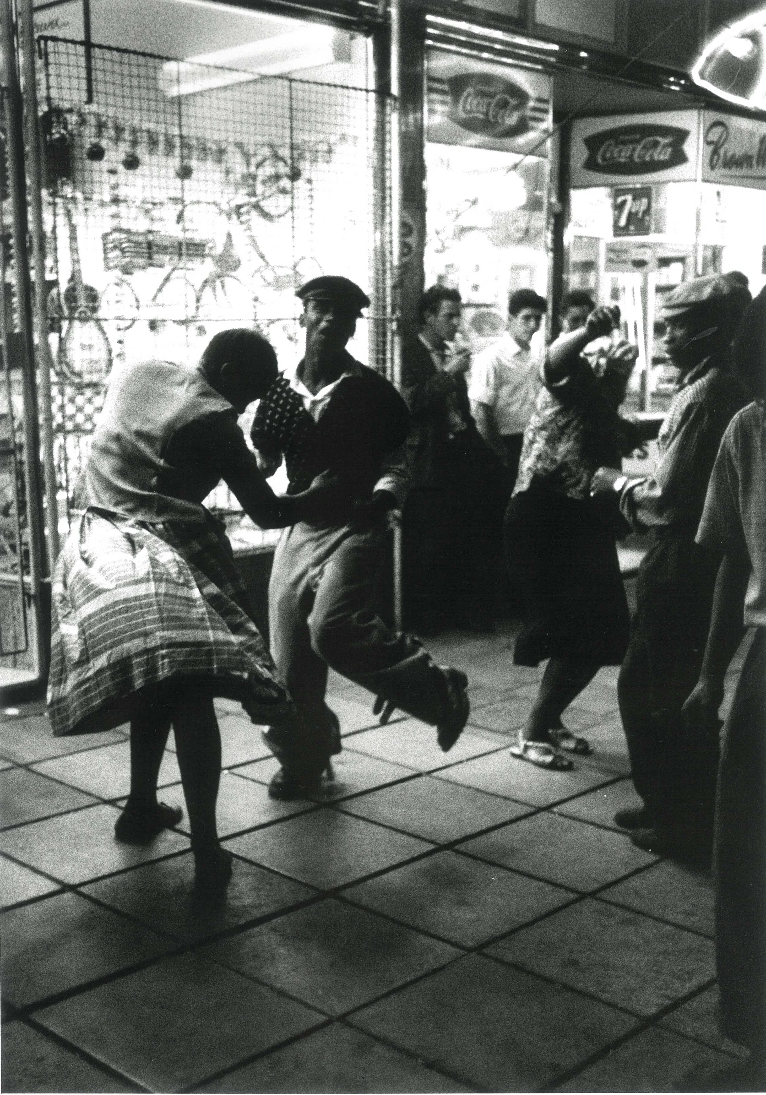 1960 – With no place to go for entertainment after work, black servants of white flats in Hilbrow, Johannesburg, dancing in the streets at night Courtesy of the Estate of John Goldblatt