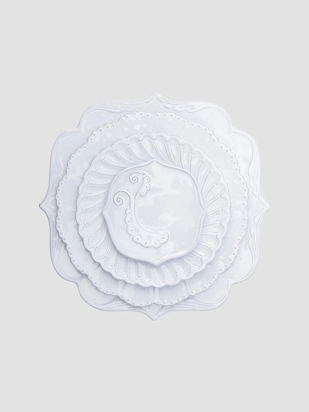 Stoneware handcrafted in Italy with variations of scalloped motifs and a distinct appearance, layered to create depth and character.