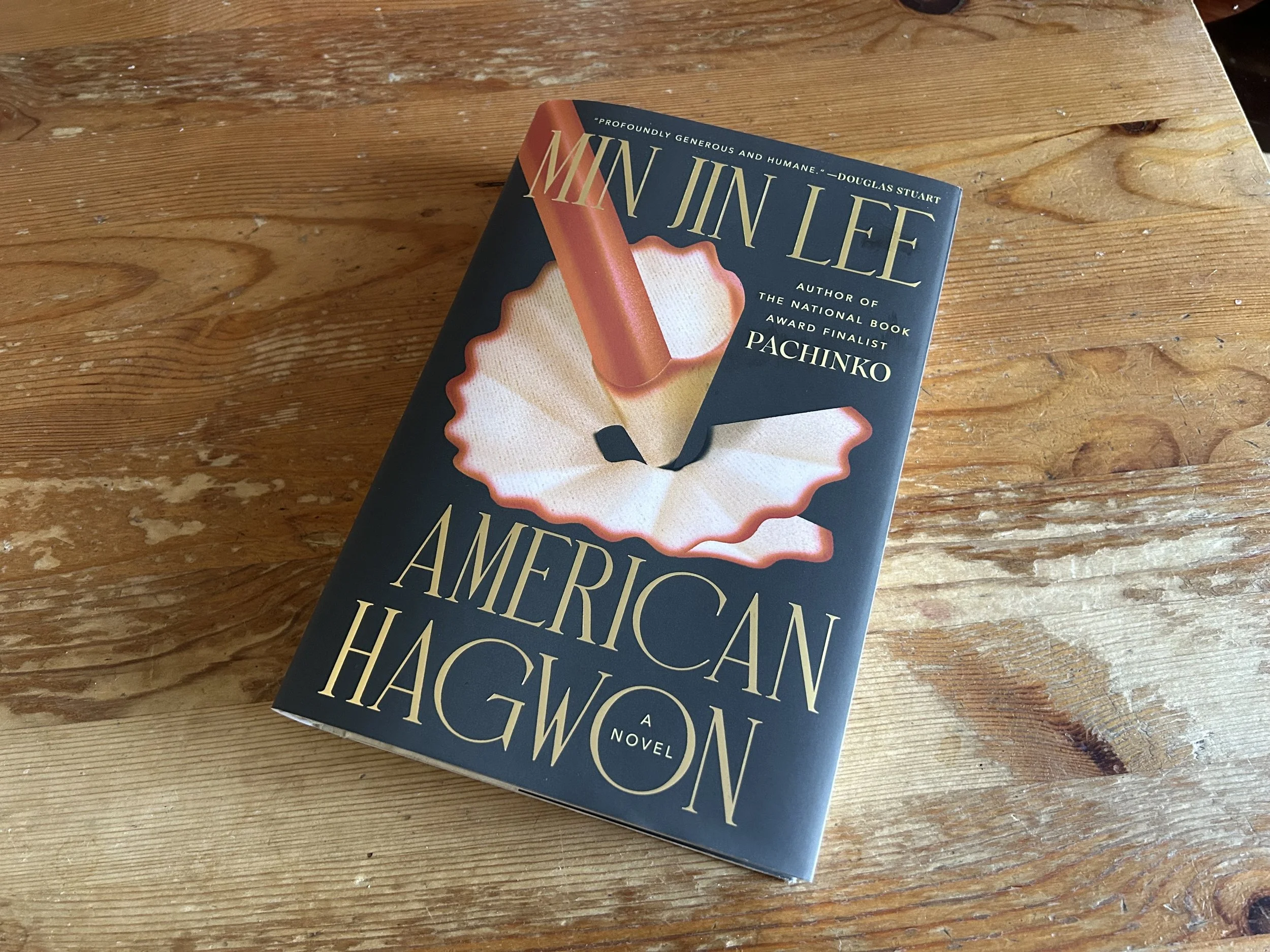 A large hardcover book with a black slip cover. The author's name is across the top and the title is across the bottom, both in gold. The illustration is a red pencil in the process of being sharpened.