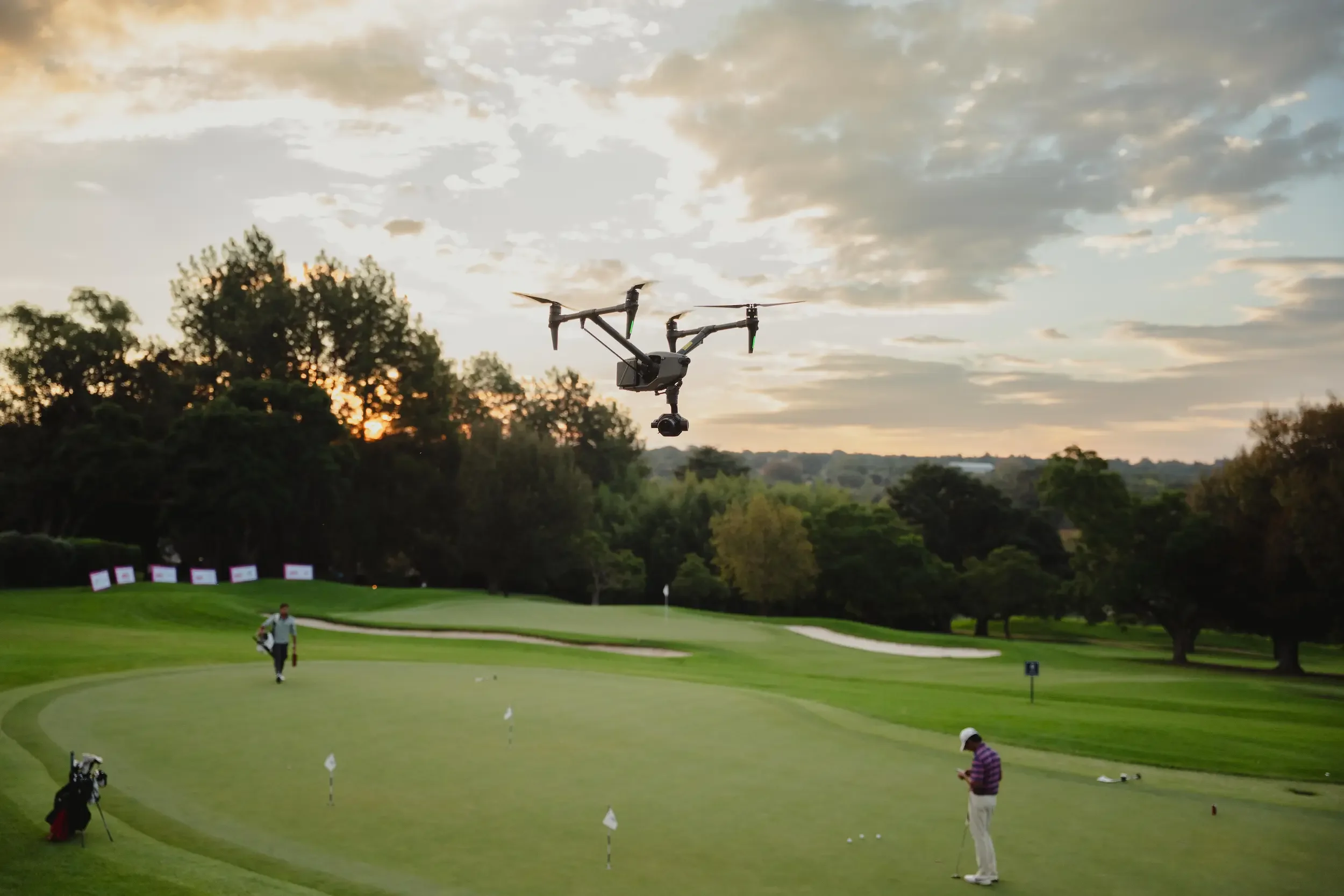 DJI Inspire 3 drone flying over golf course at sunset