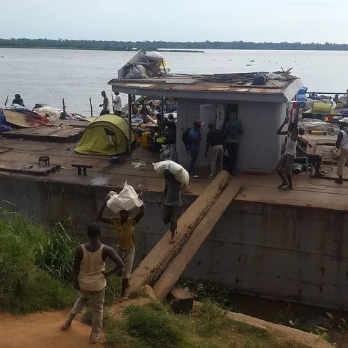 Loading and unloading a boat in Lisala.