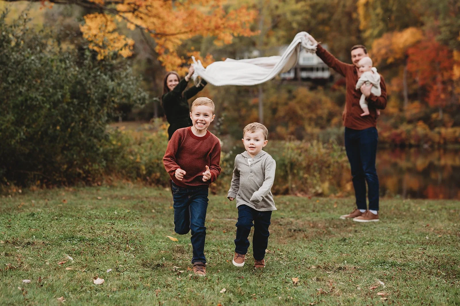 two brothers in Ridgefield, ct park run toward camera while parents stand behind
