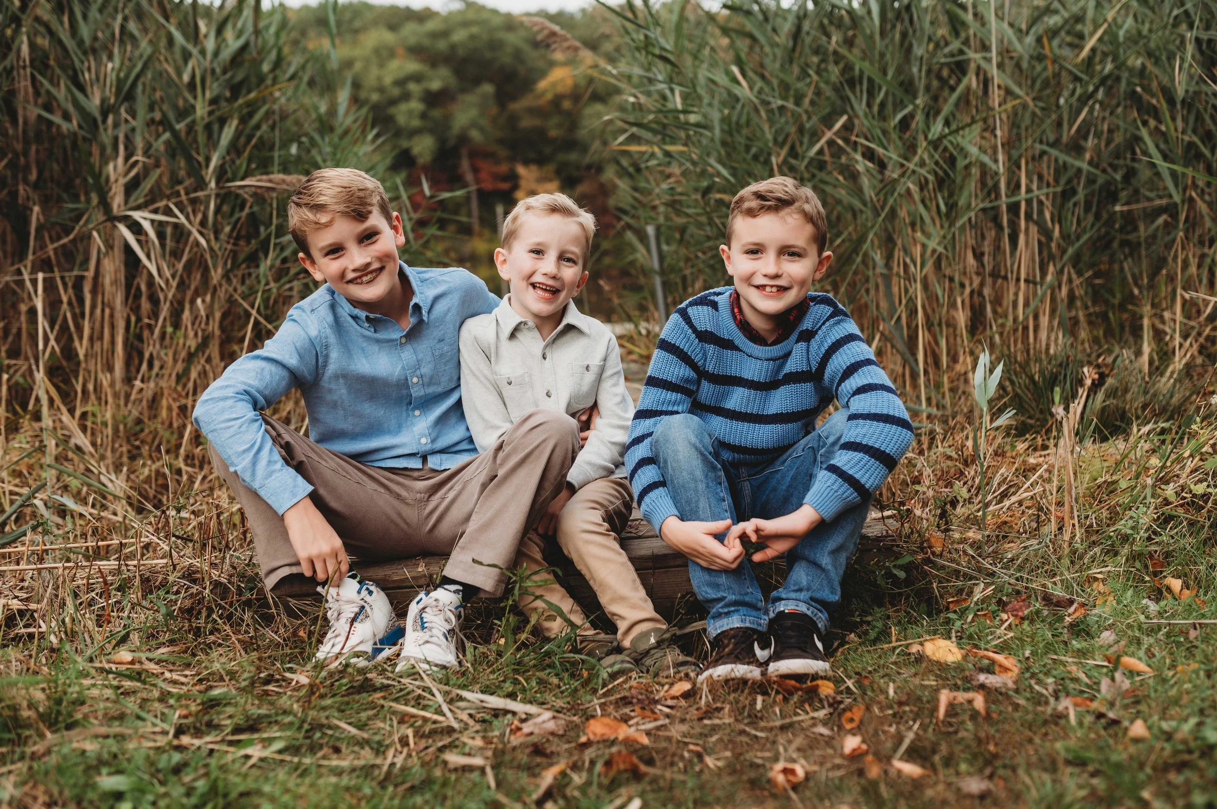 three brothers sit together wearing blues and tans, ridgefield, ct park